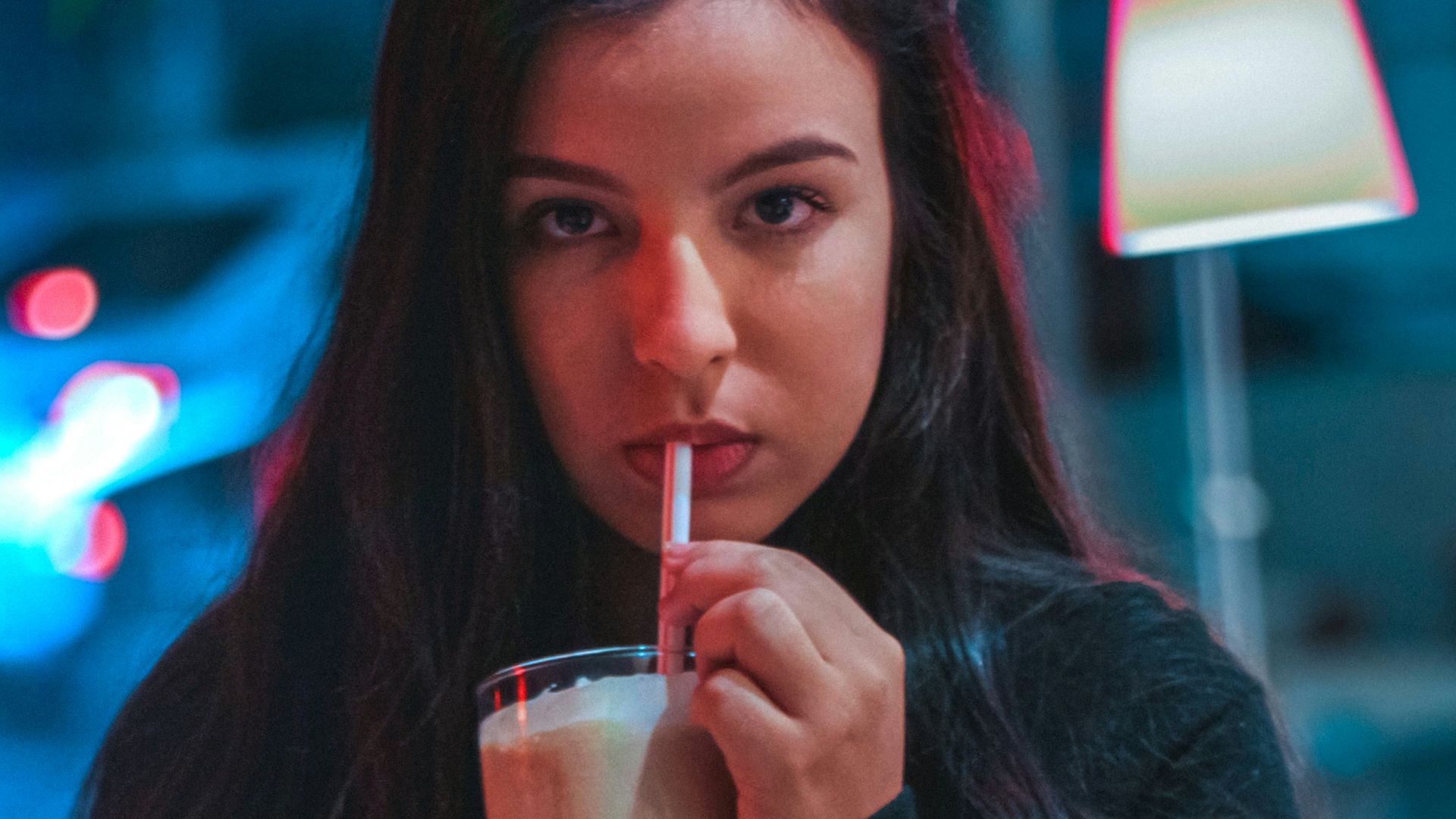 woman in black long sleeve shirt holding clear drinking glass