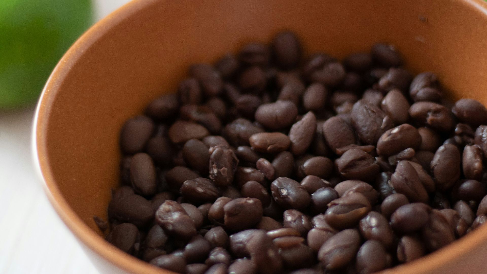 a bowl filled with black beans next to limes