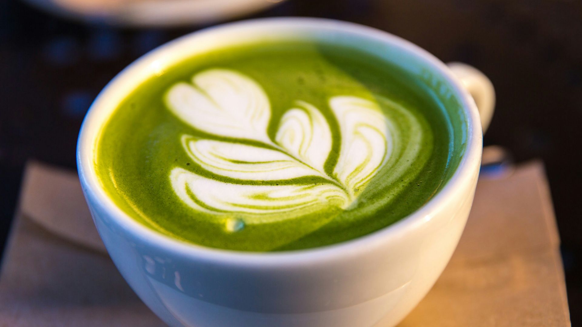 white ceramic teacup filled of matcha tea