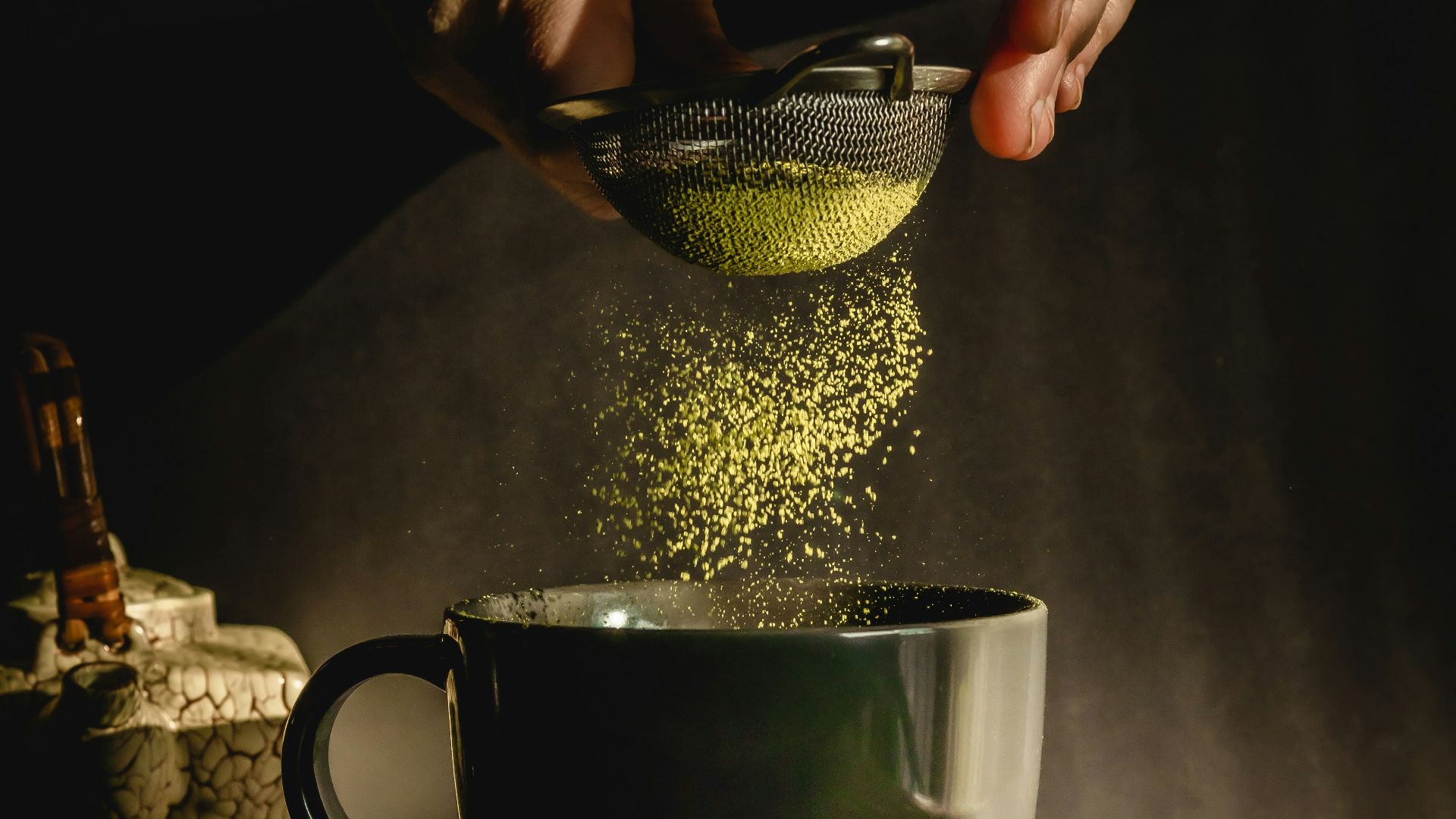person pouring water on black ceramic mug