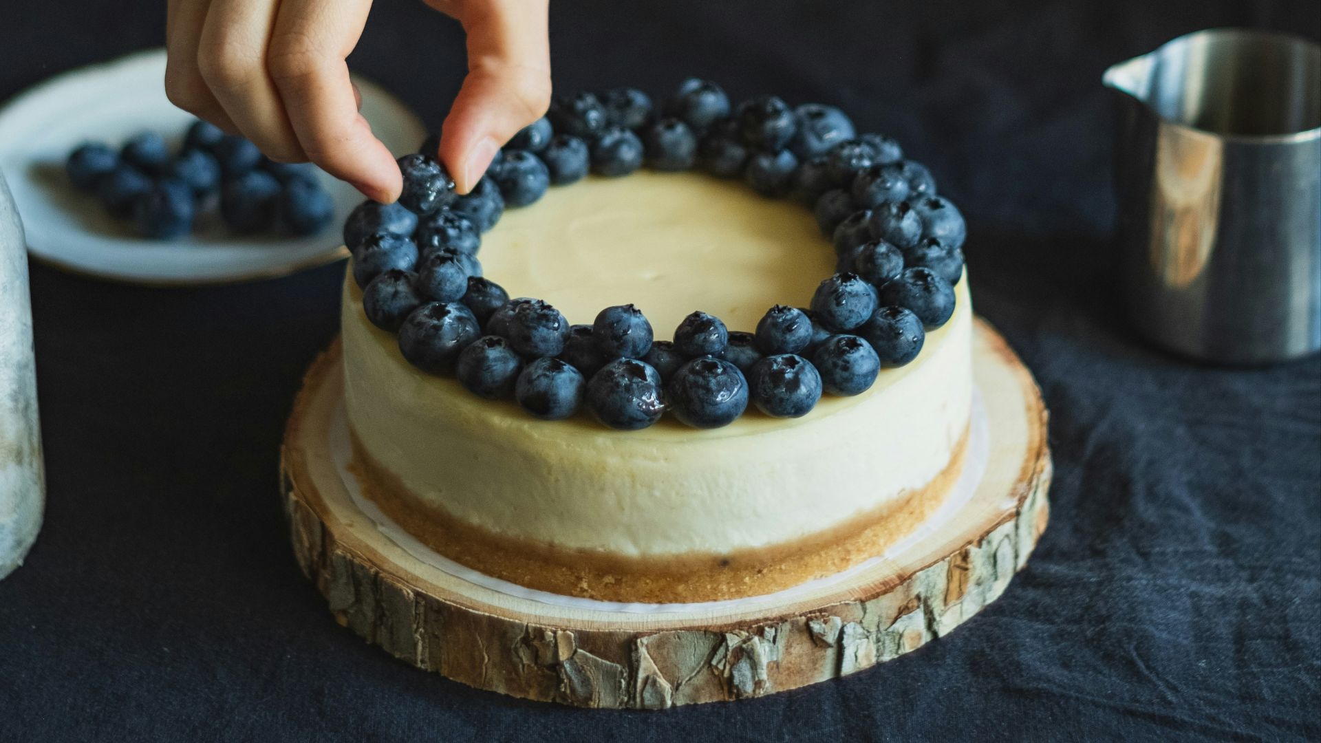 person holding cake with white icing and blue icing