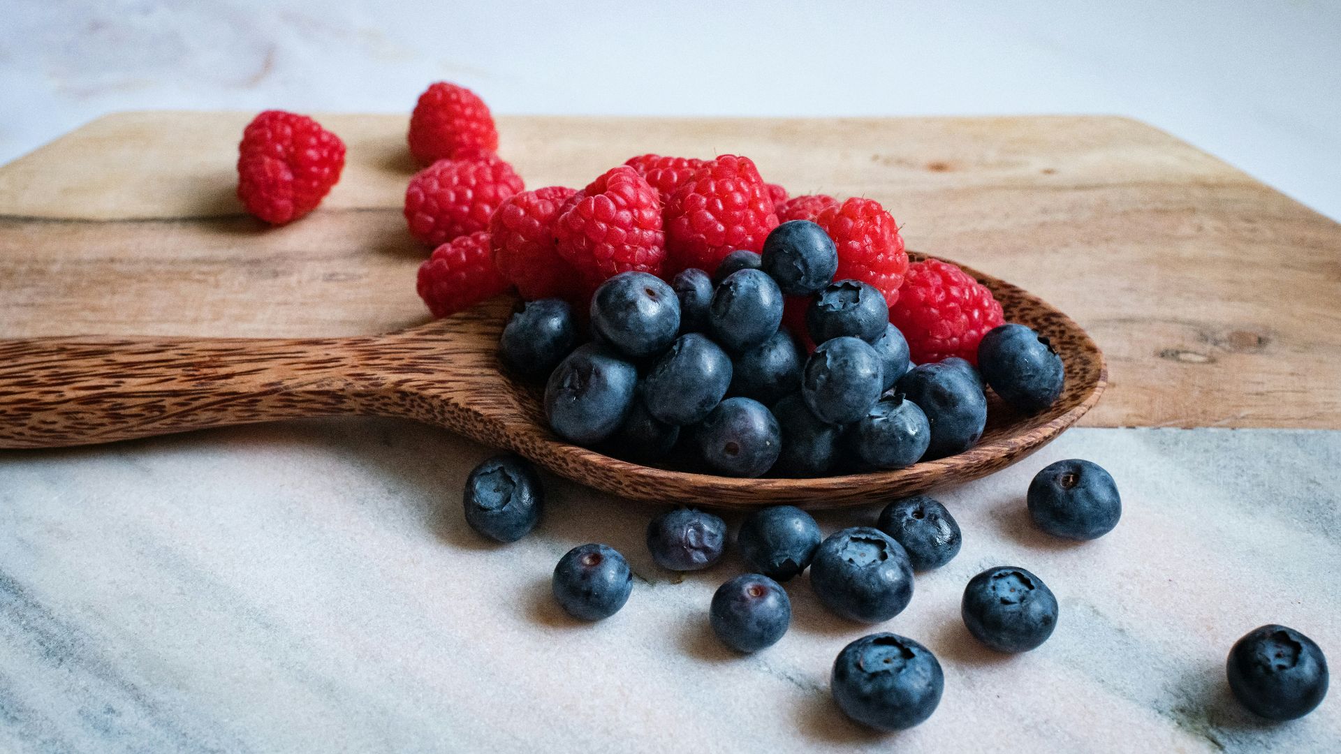 black berries on brown wooden spoon