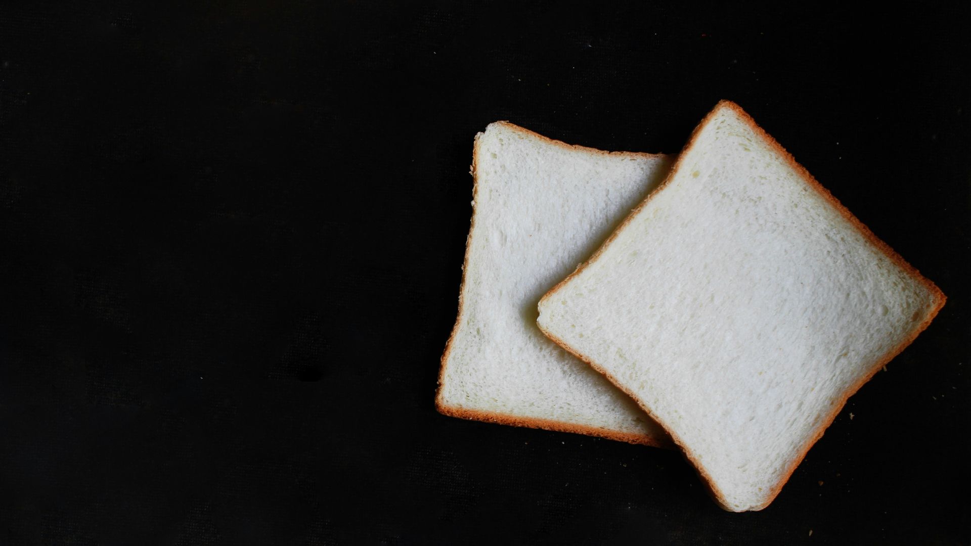 two slices of breads on top of black surface