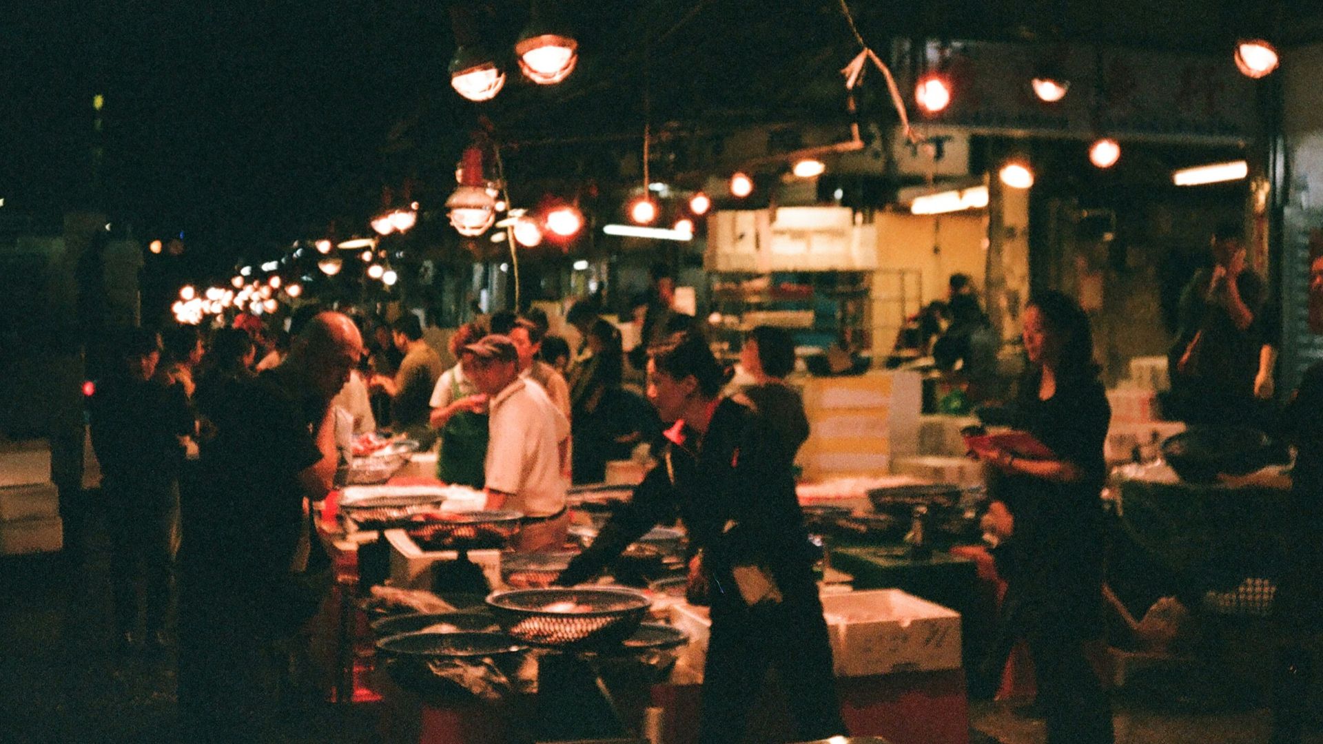 a group of people standing around a food market