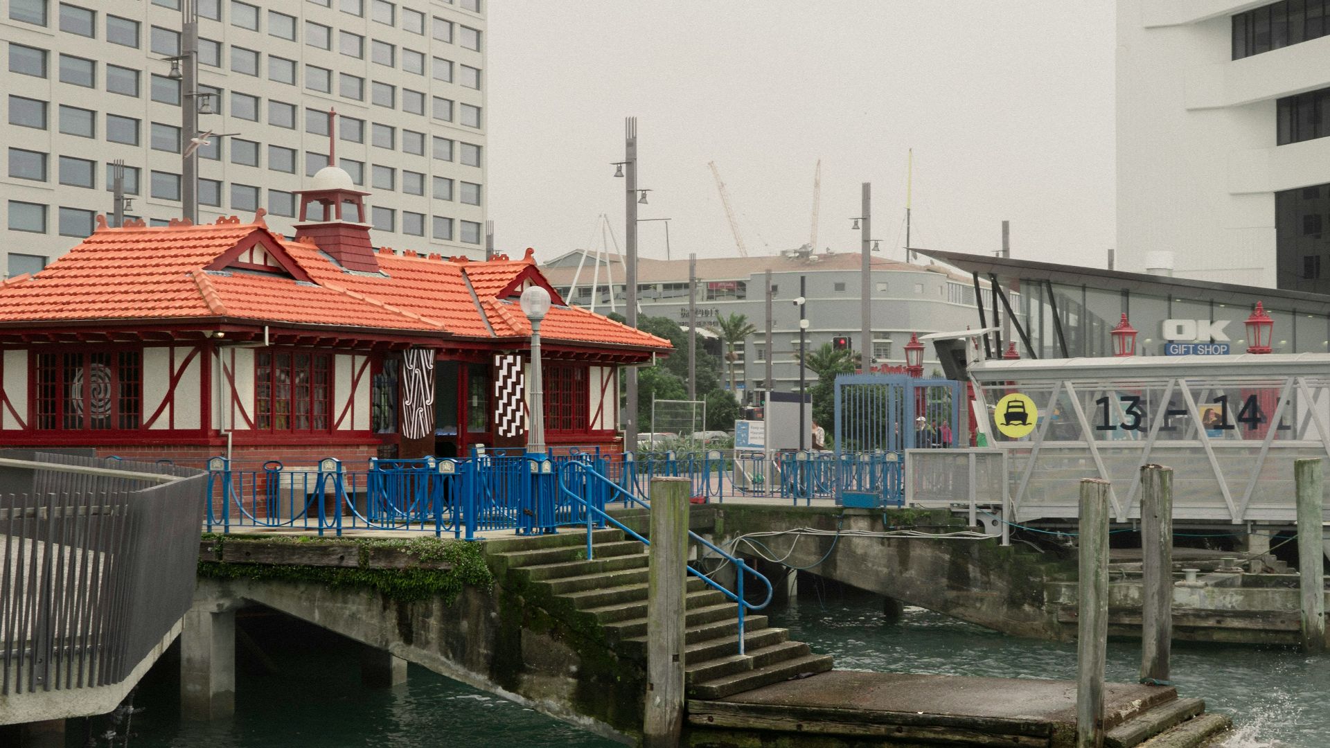 a boat dock with a building and a bridge