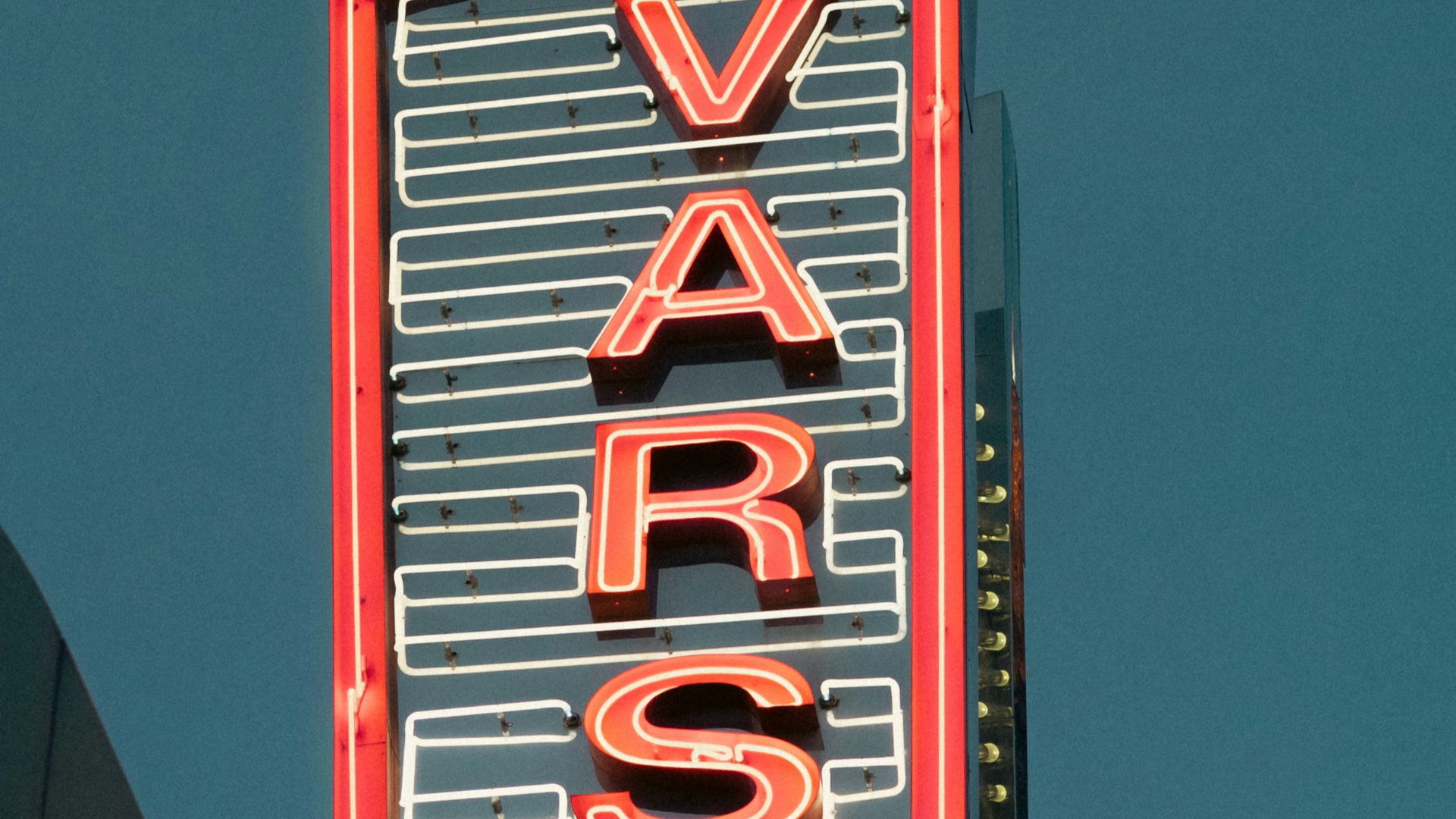 a very tall neon sign on the side of a building