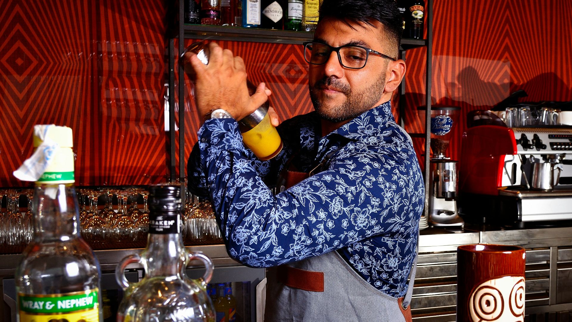 a man in an apron is making a drink