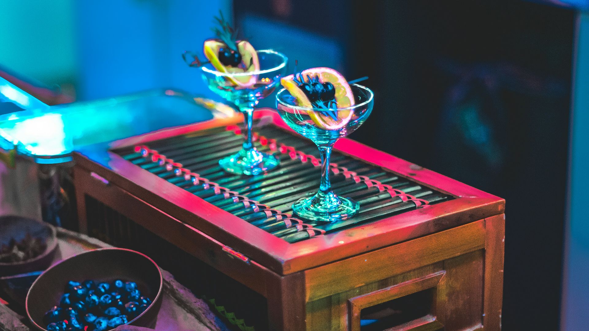 a table topped with a wooden tray filled with glasses