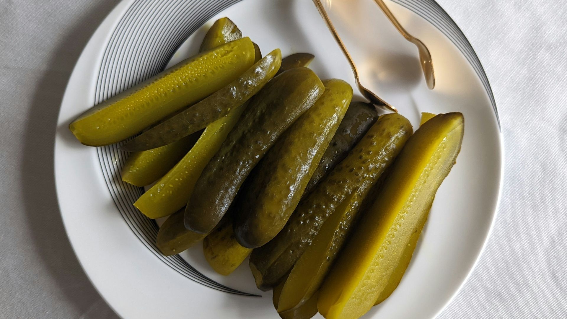 a white plate topped with pickles next to a fork