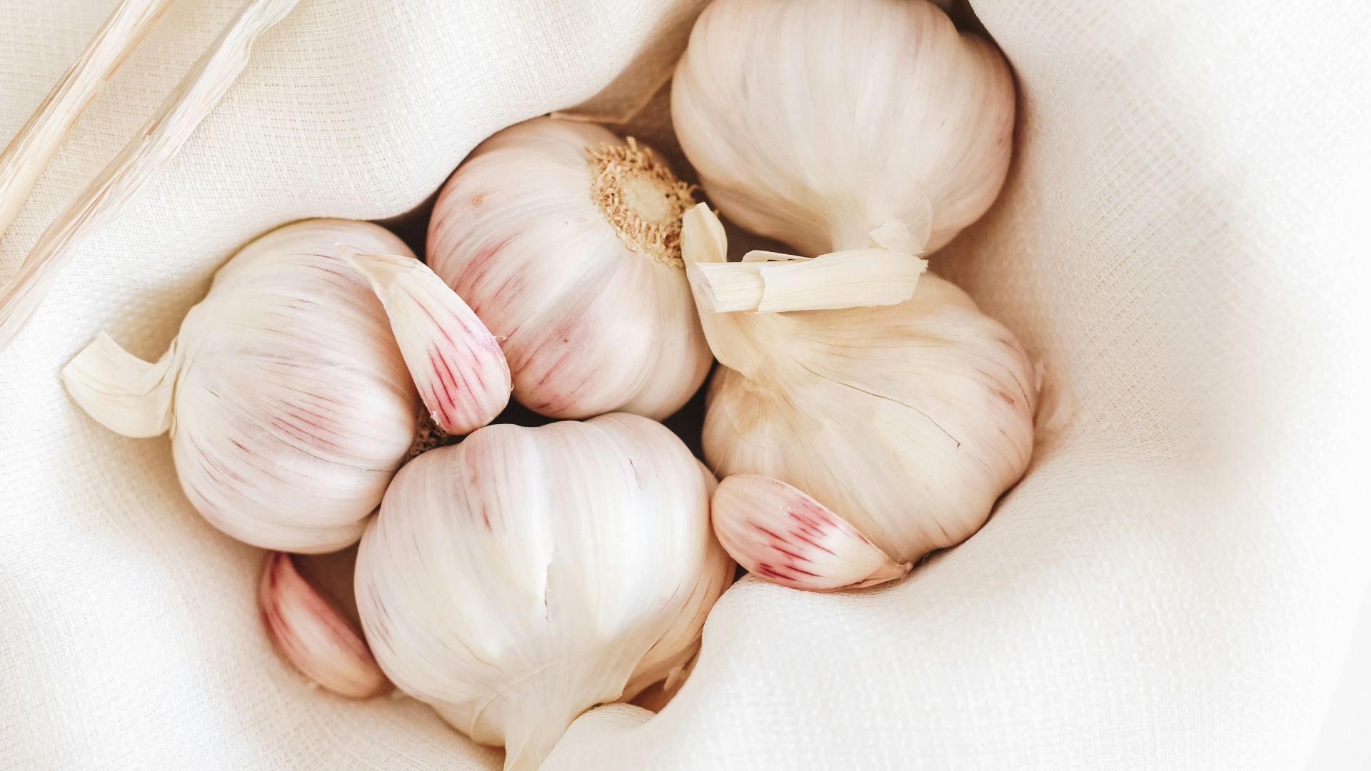 five garlic on white textile