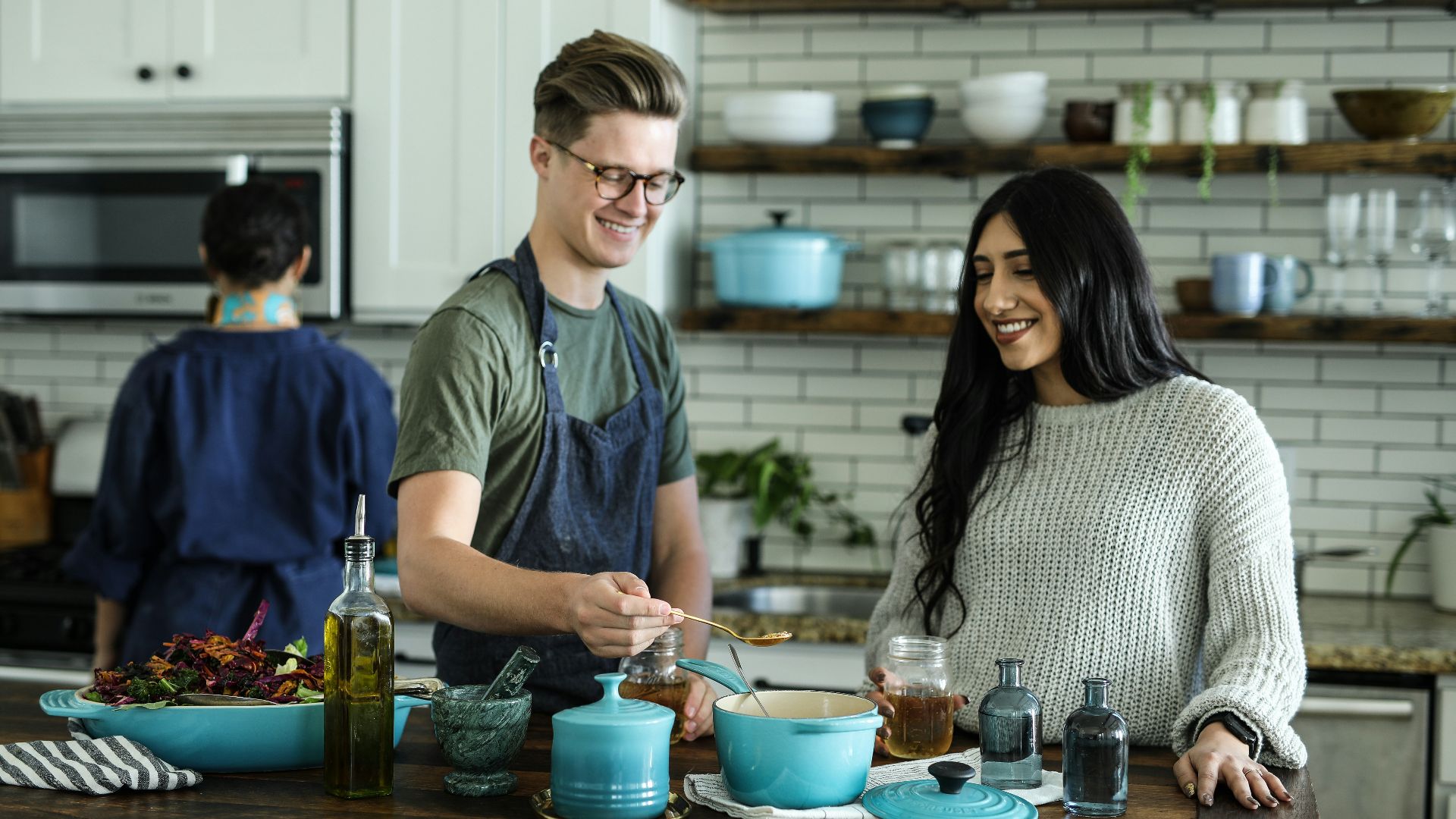 smiling man standing and mixing near woman in kitchen area of the house