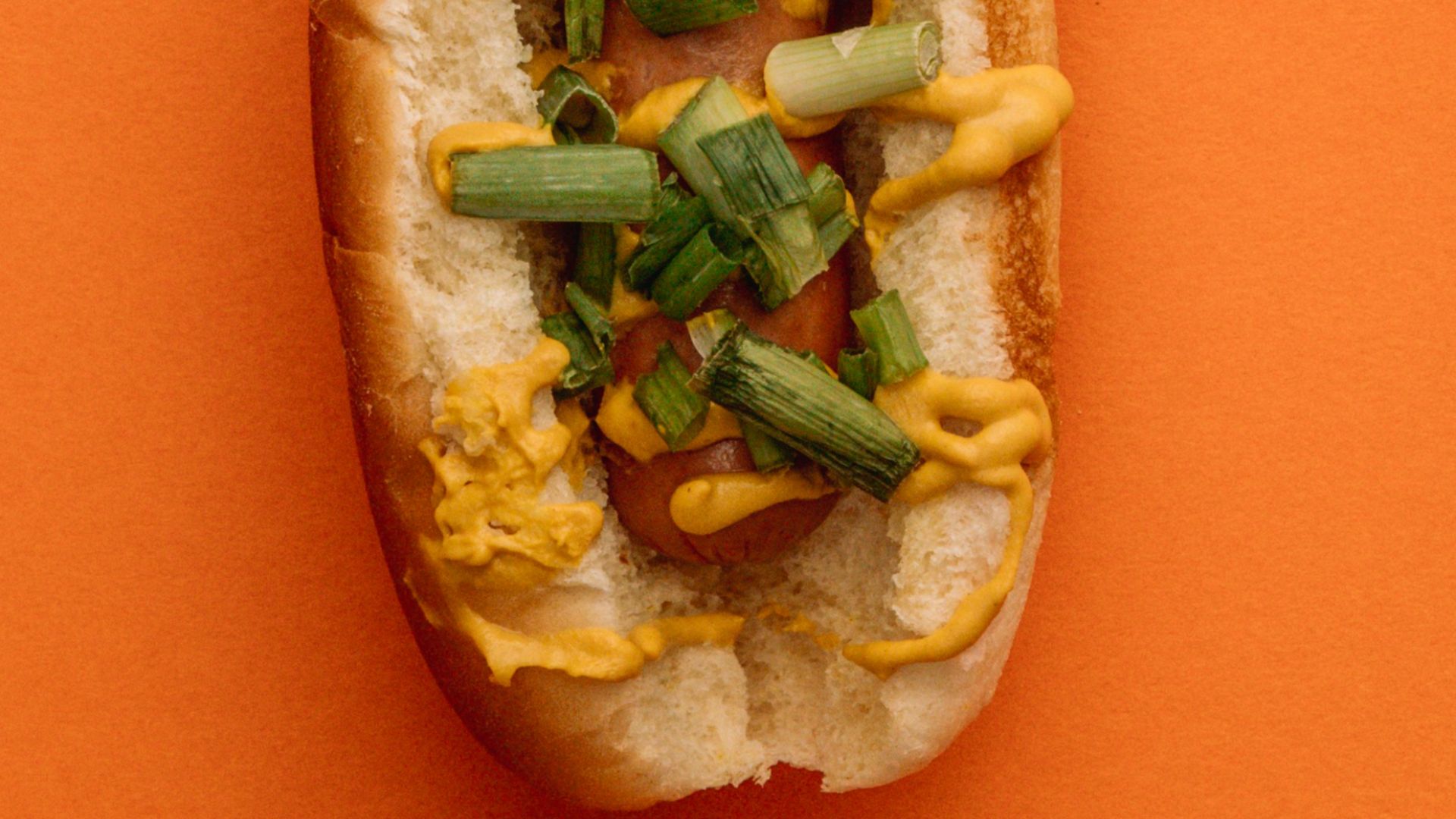 sandwich with green vegetable on orange surface