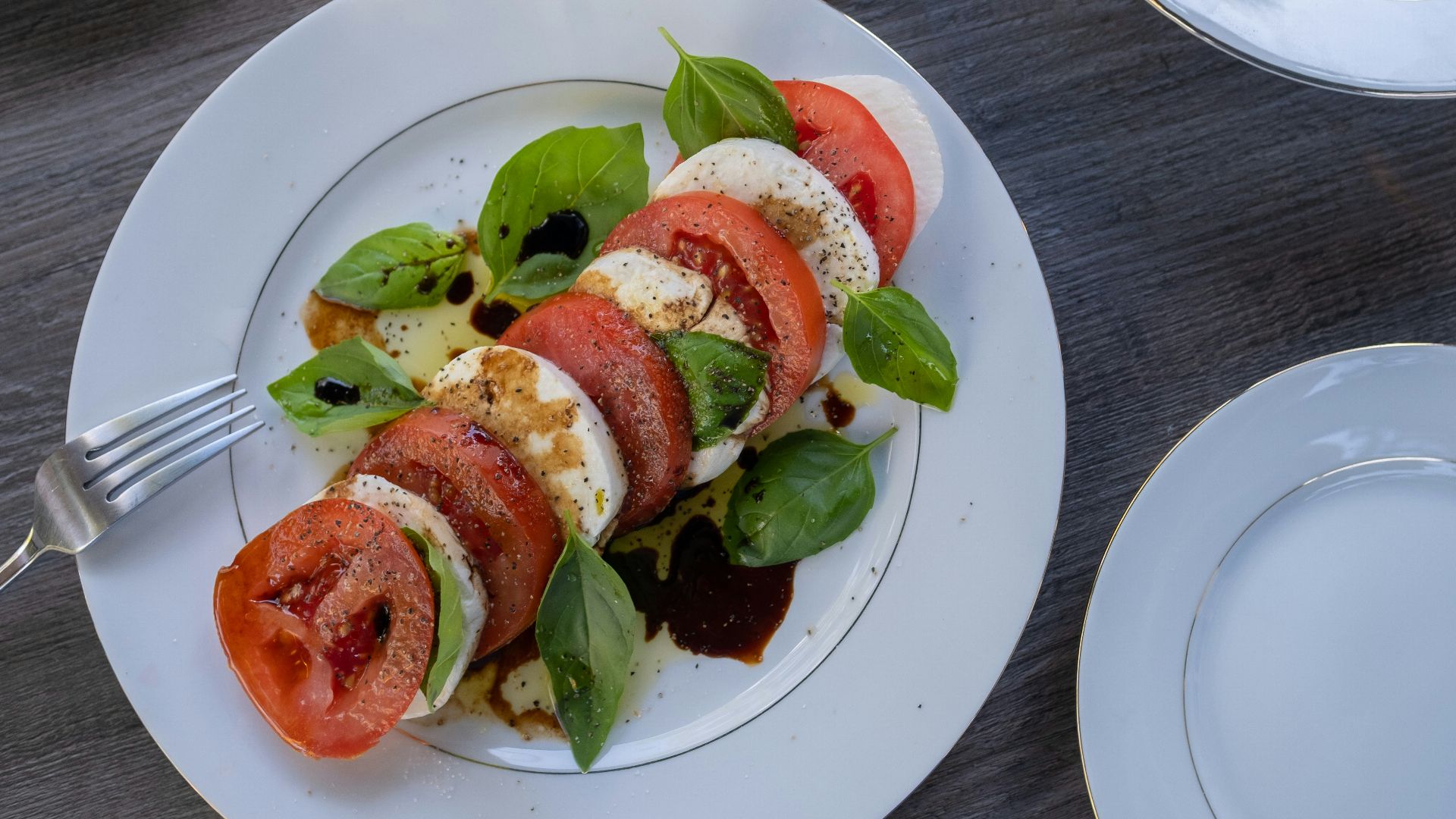 a white plate topped with sliced tomatoes and veggies