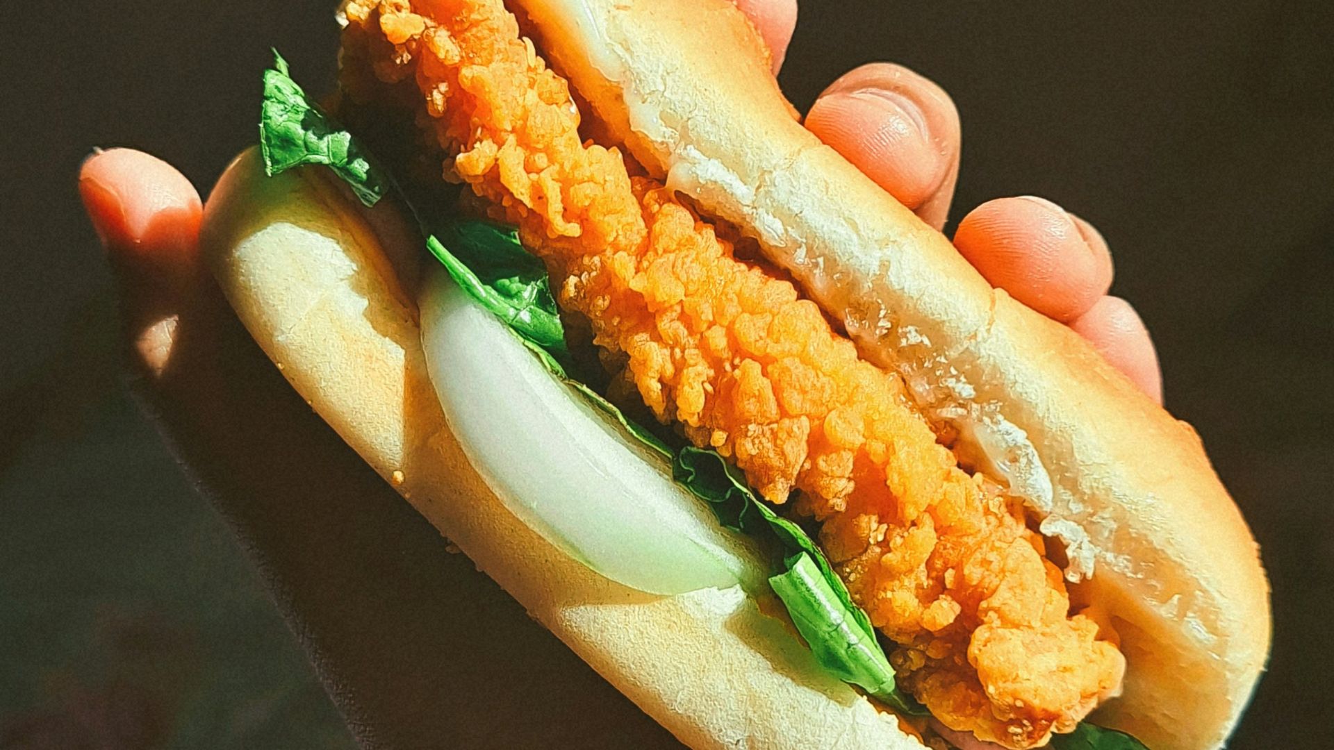 a person holding a sandwich in their hand