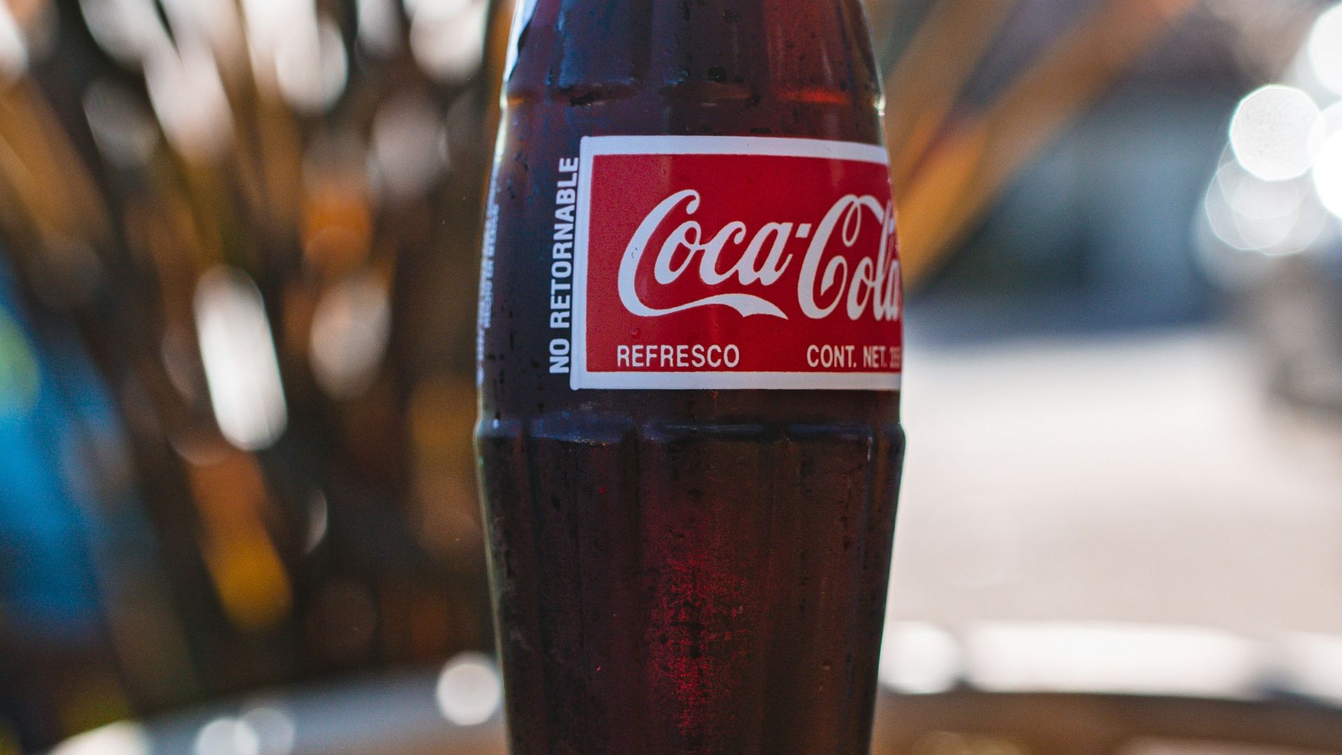 coca cola glass bottle on brown wooden table