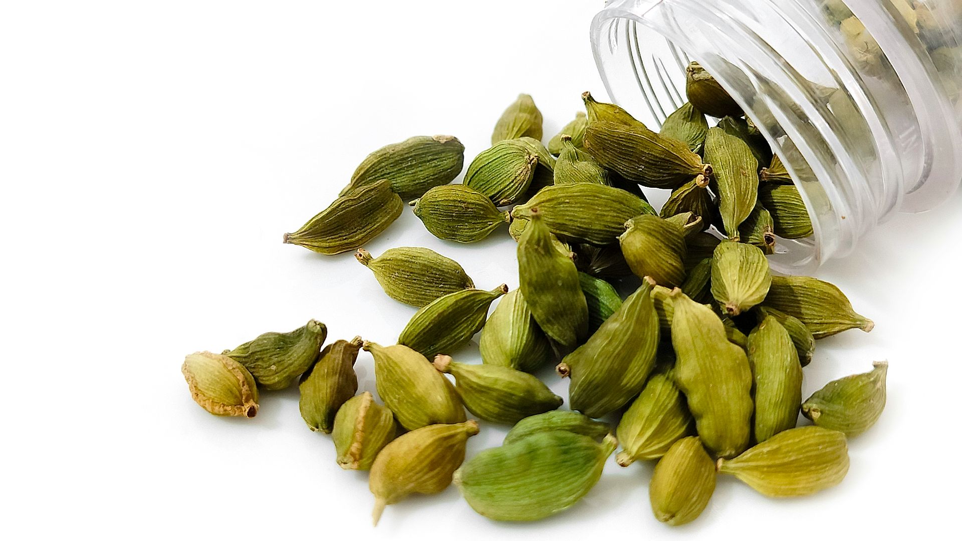 a pile of pistachio seeds next to a bottle of water