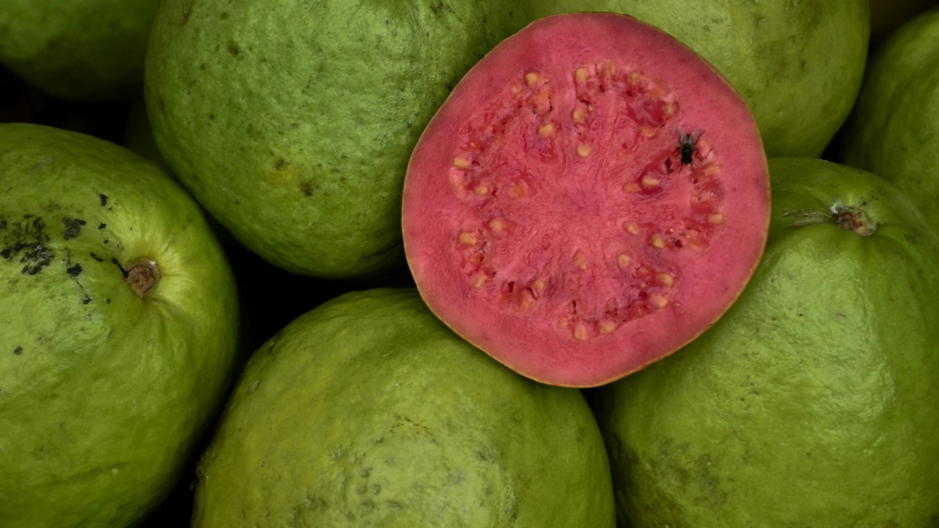a pile of green and red fruit sitting on top of each other