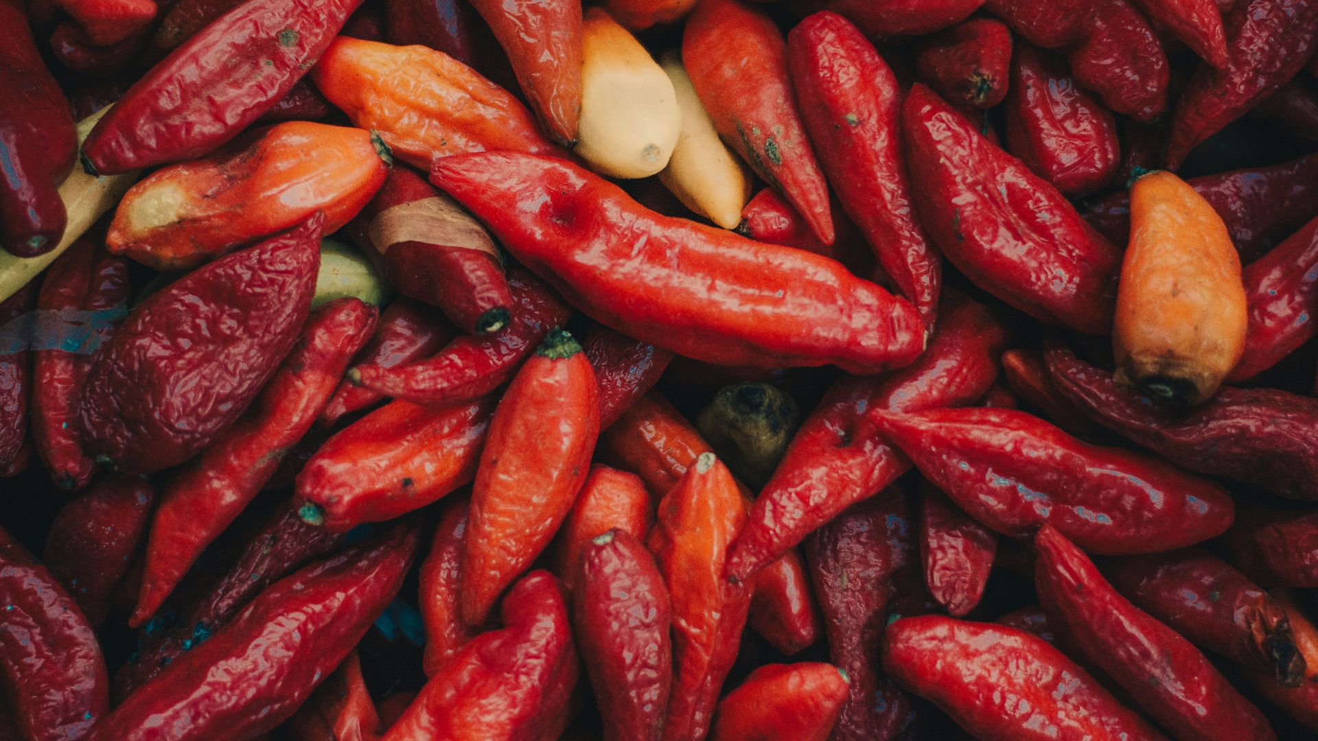 a pile of red peppers and other vegetables