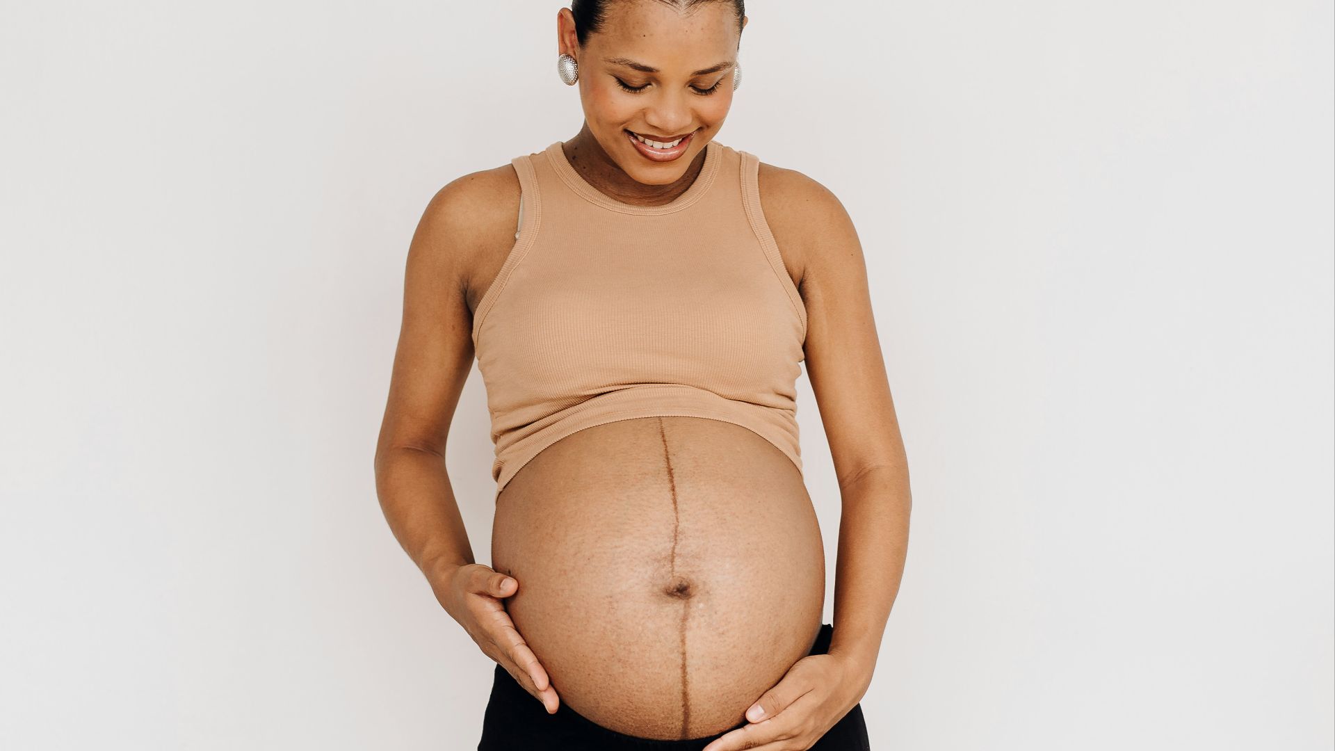 a pregnant woman standing with her hands on her belly