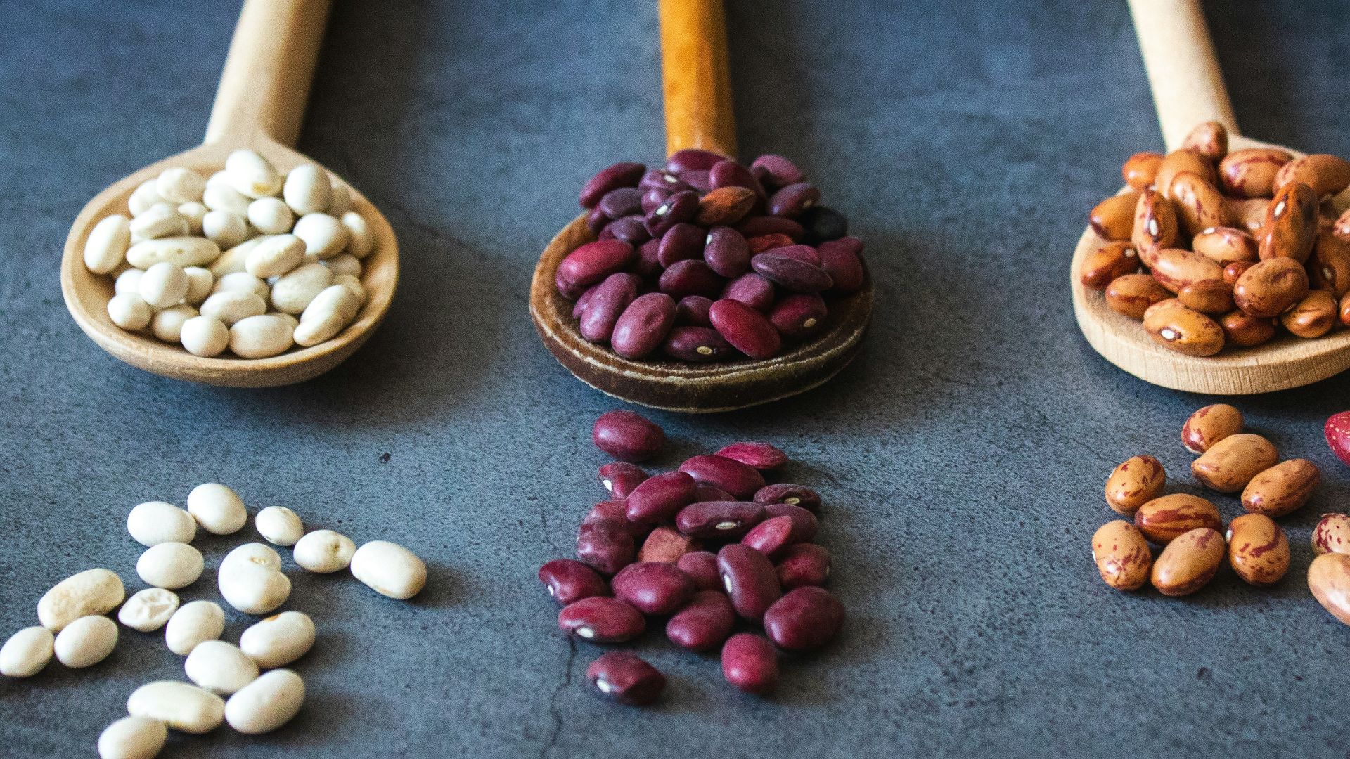 brown wooden spoon with red and brown beans