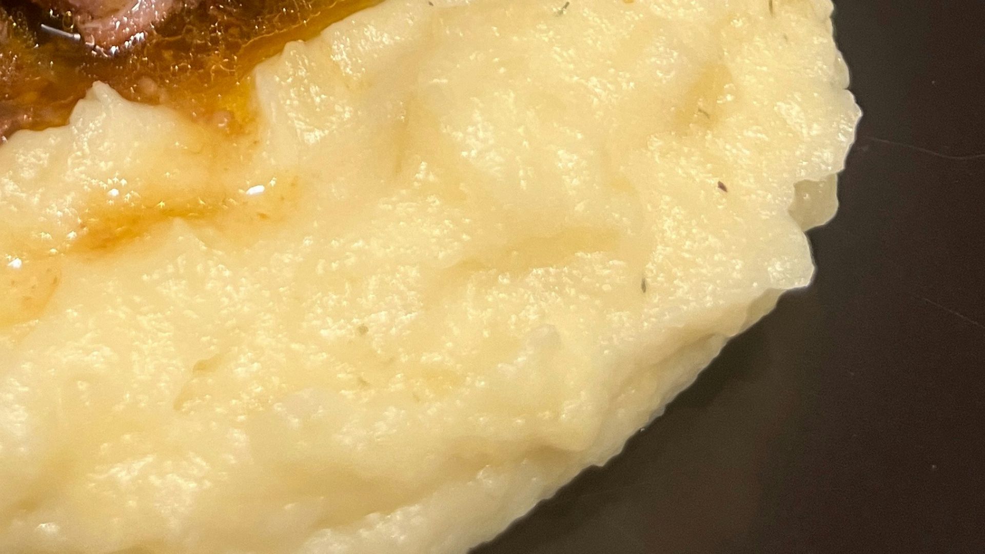 A plate of mashed potatoes with beef and gravy