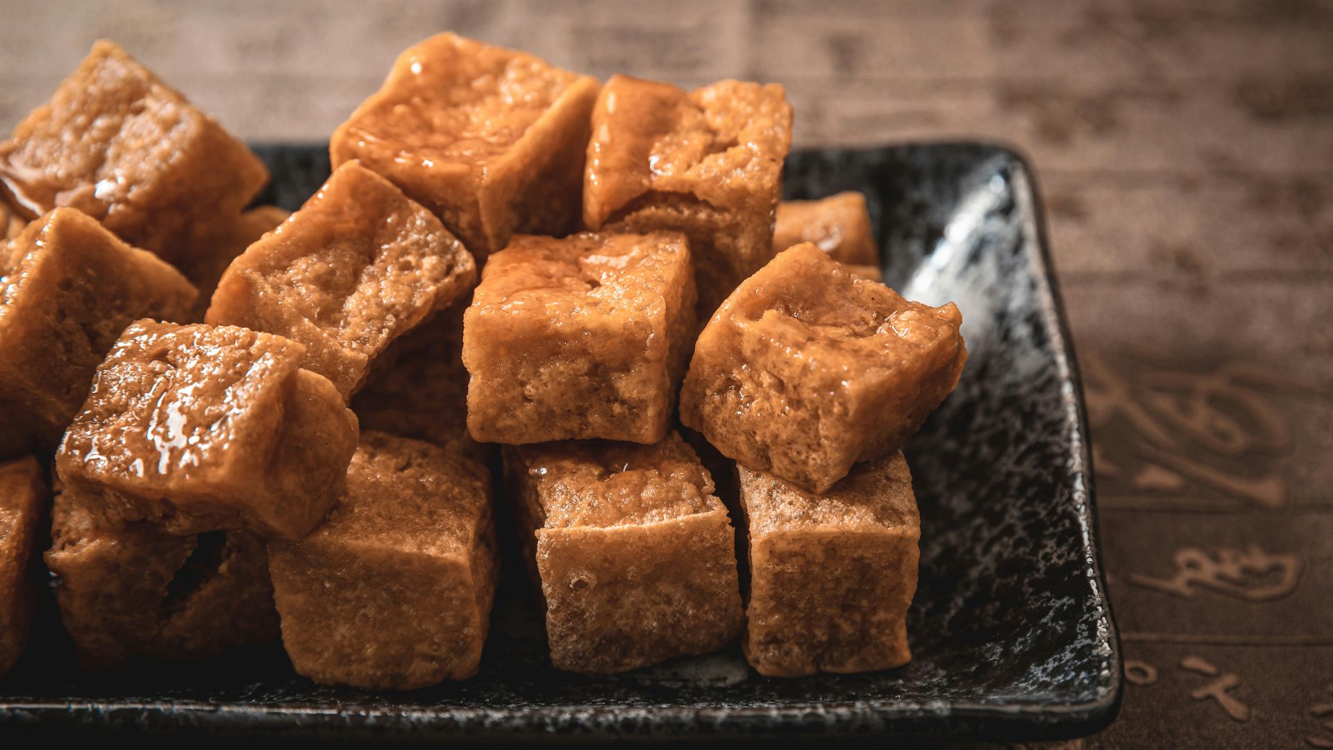 Fried tofu cubes are piled on a plate.