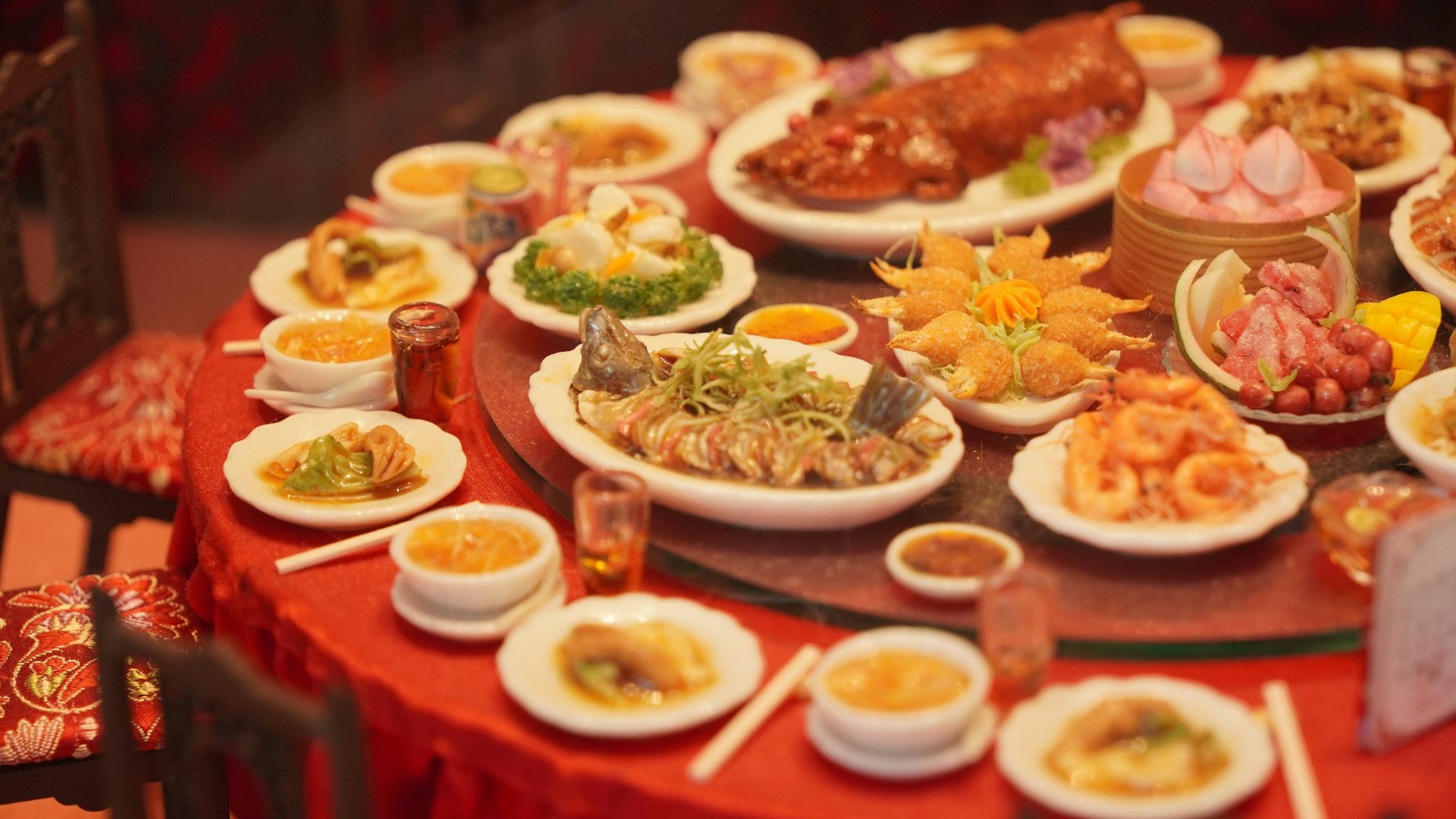 Table laden with diverse asian dishes and roasted pig.