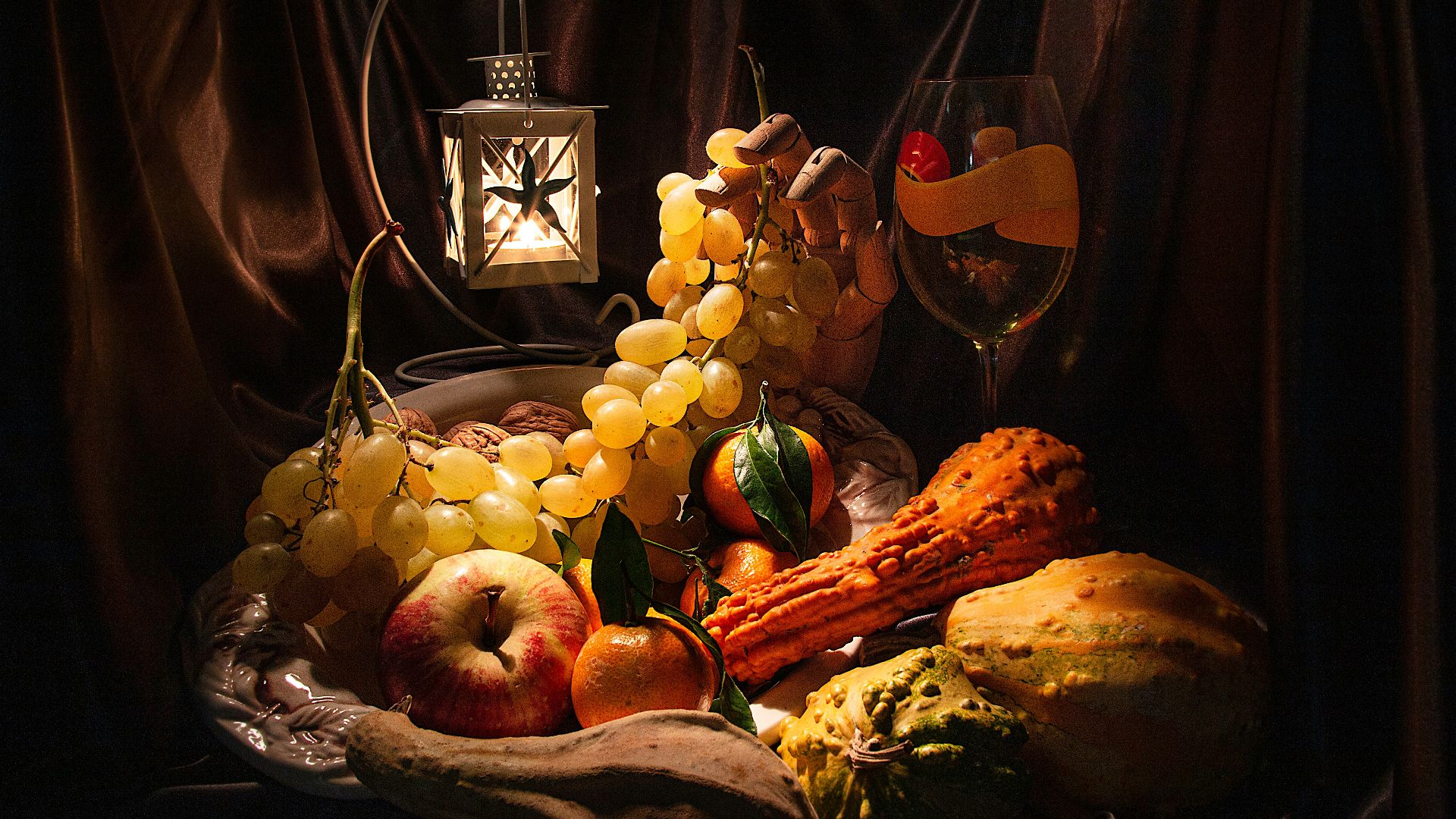 a still life of grapes, apples, bread, and a lantern