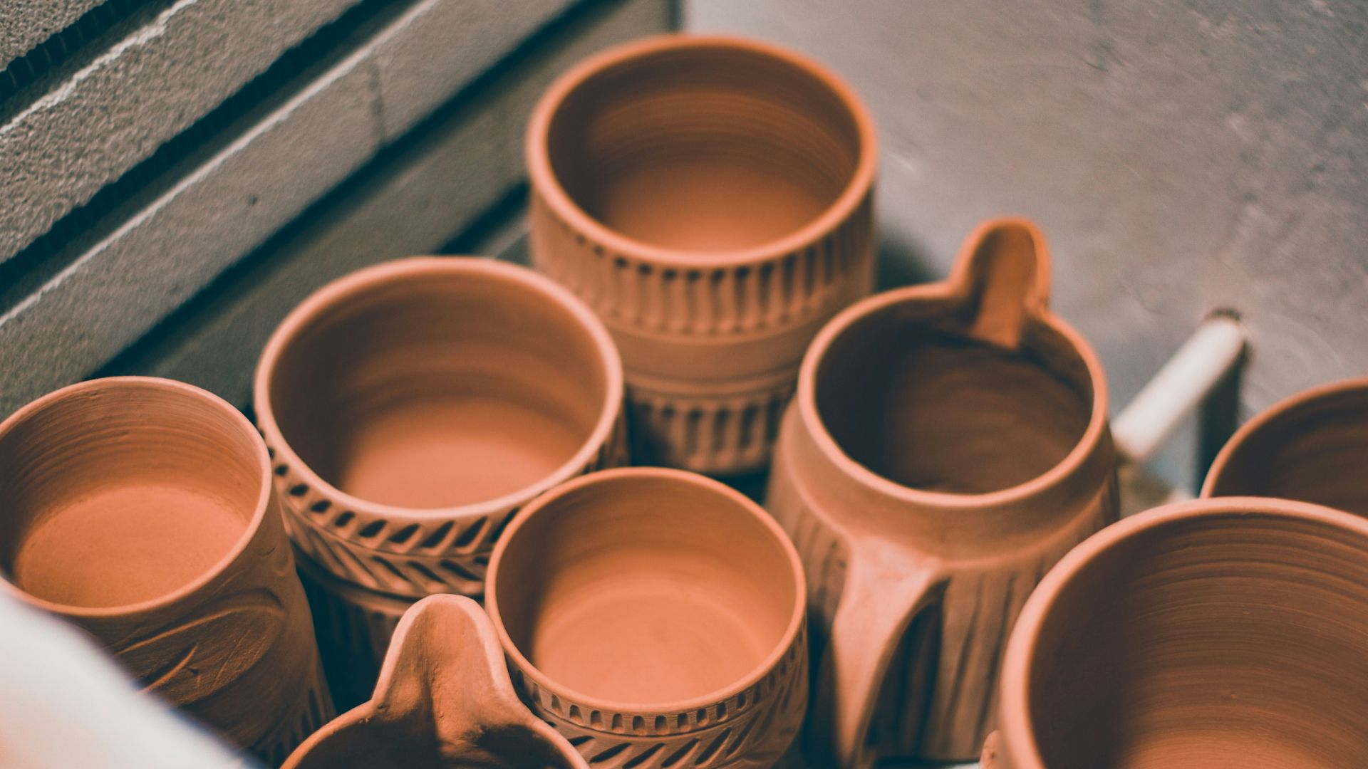 brown ceramic mugs on brown wooden shelf