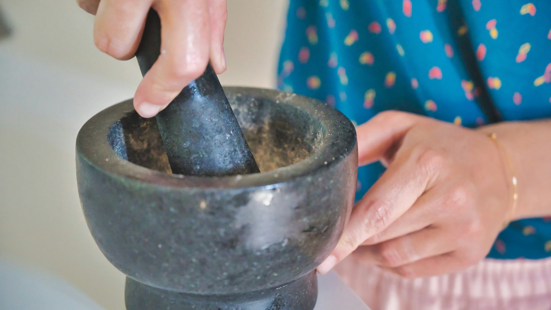 person holding gray mortar and pestle