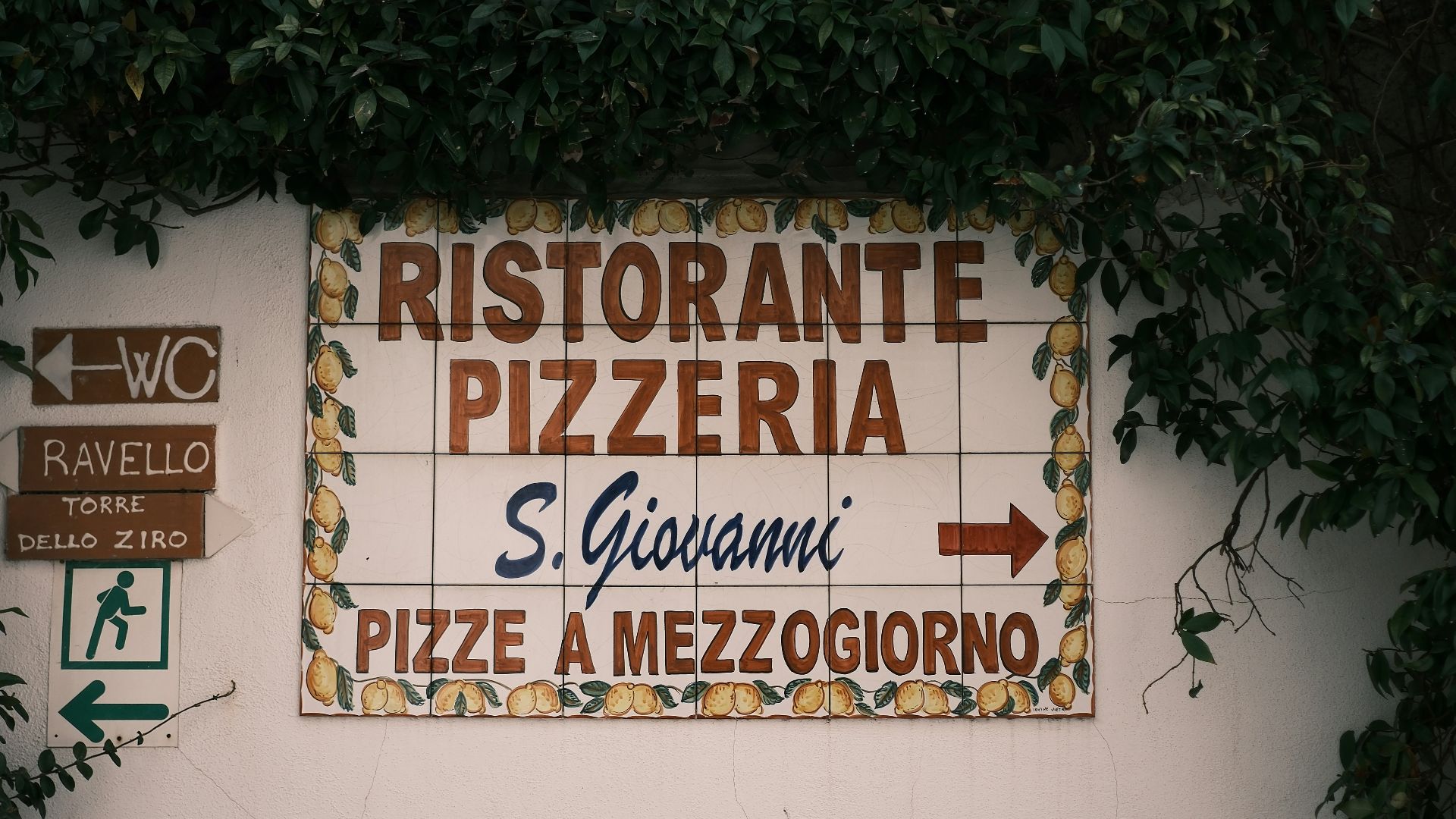 a bench sitting in front of a wall covered in signs