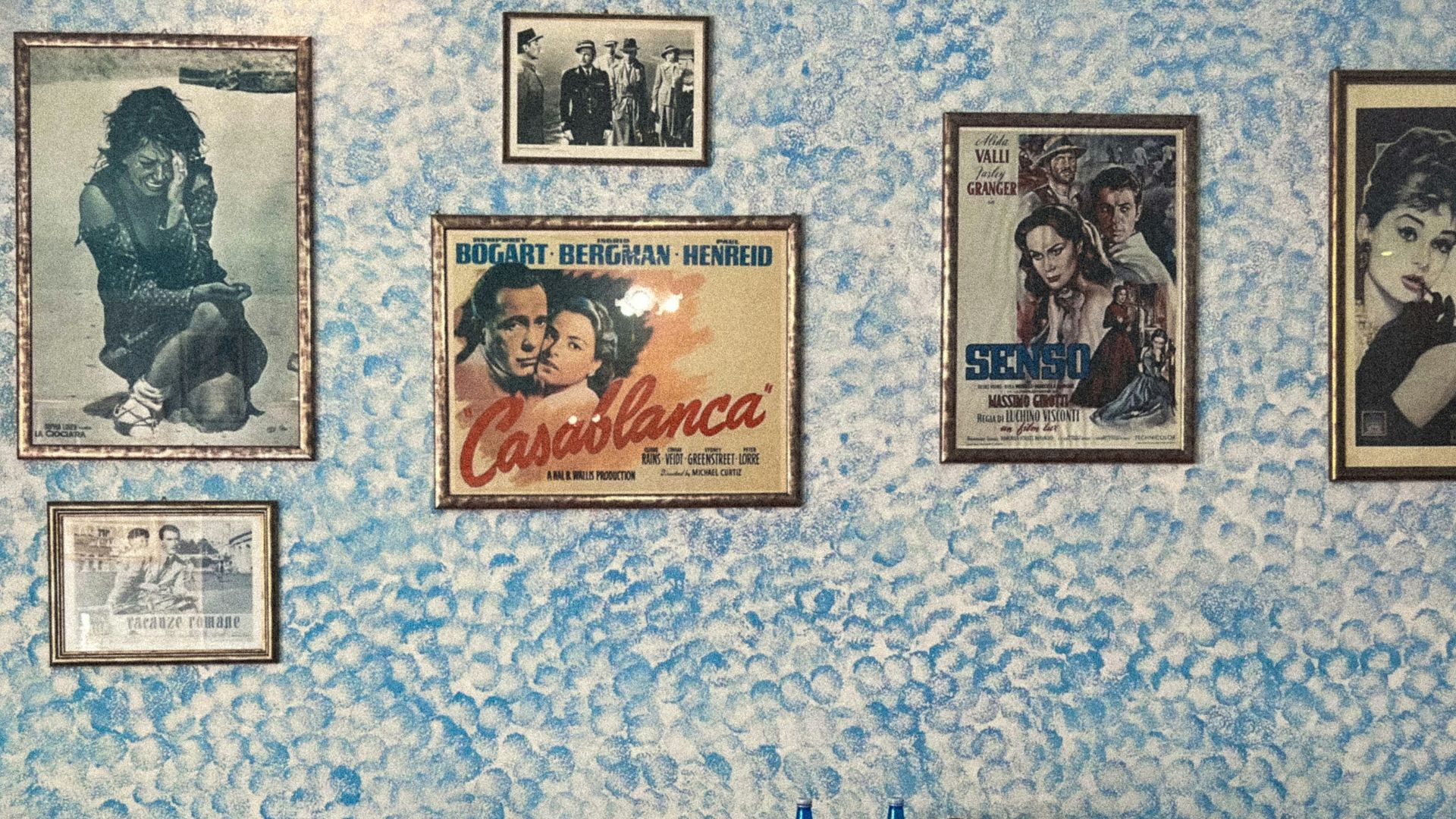 a table with a red tablecloth and chairs with pictures on the wall