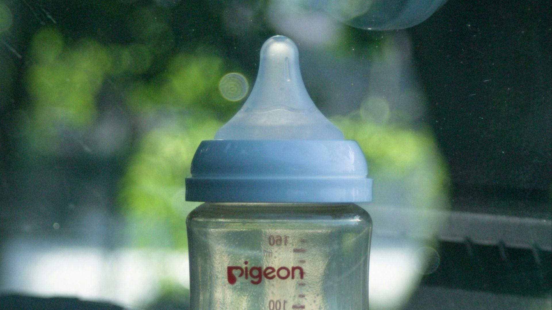 A baby bottle sits inside a car.