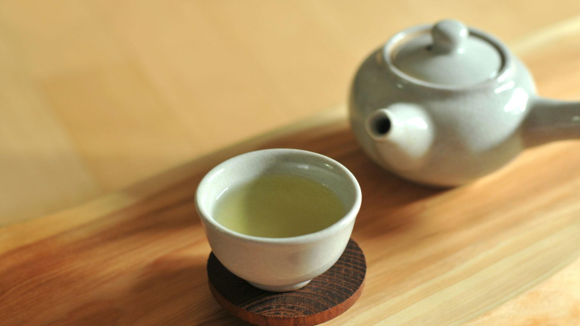 white ceramic teacup on brown wooden table
