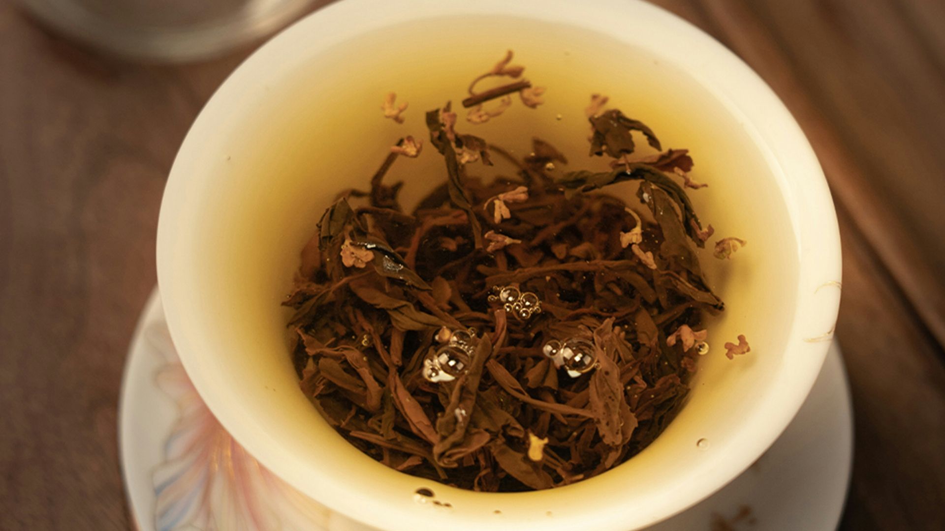 a cup filled with tea sitting on top of a white plate