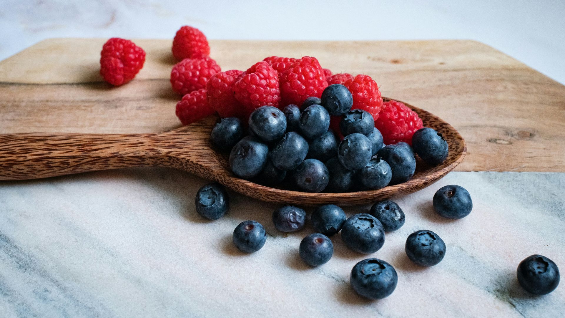 black berries on brown wooden spoon