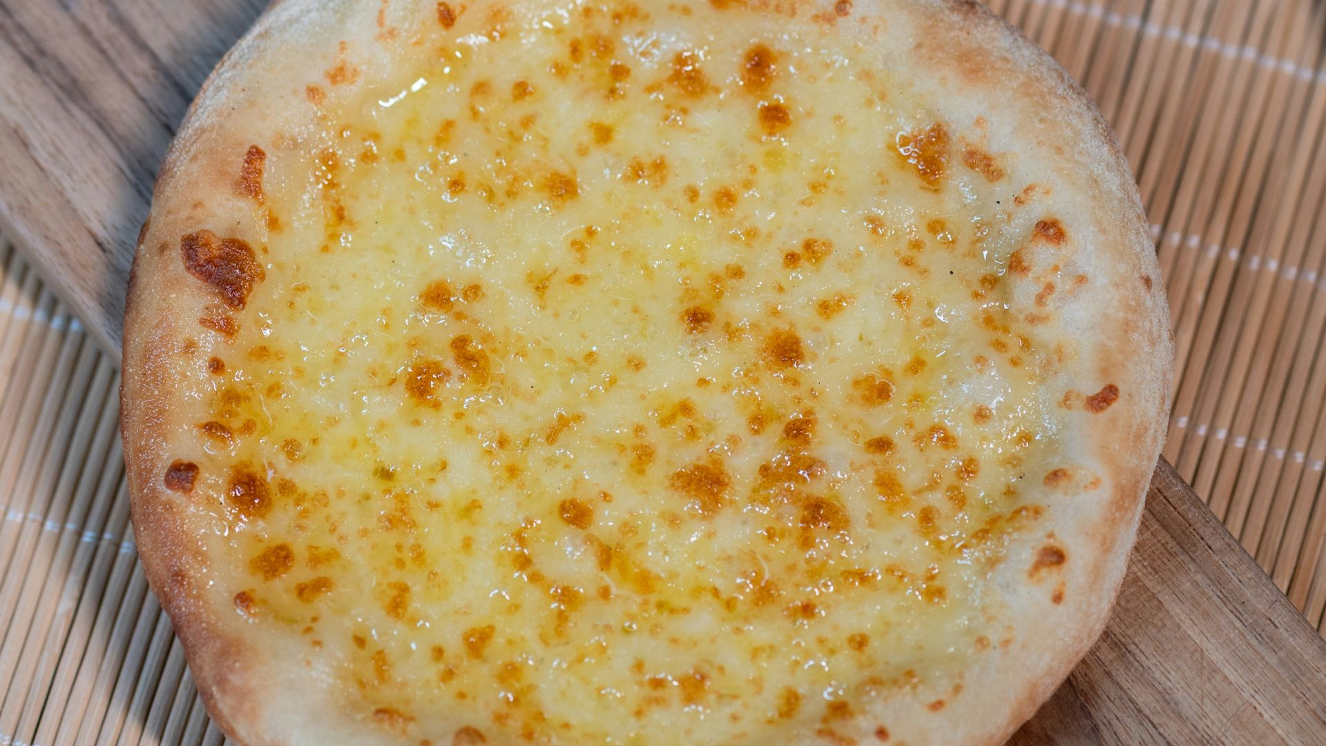Cheese bread is served on a wooden board.