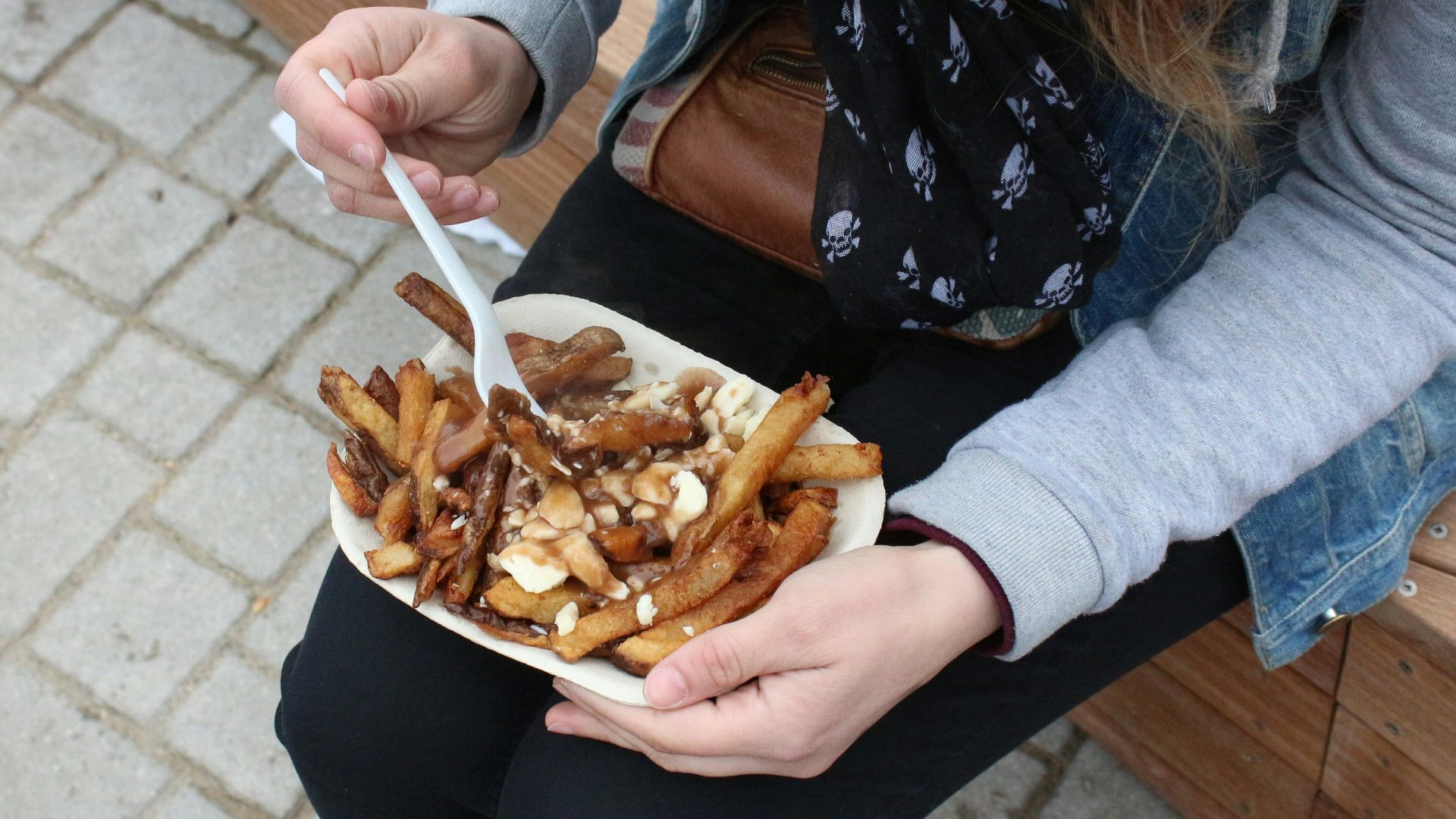 person holding burger with fries