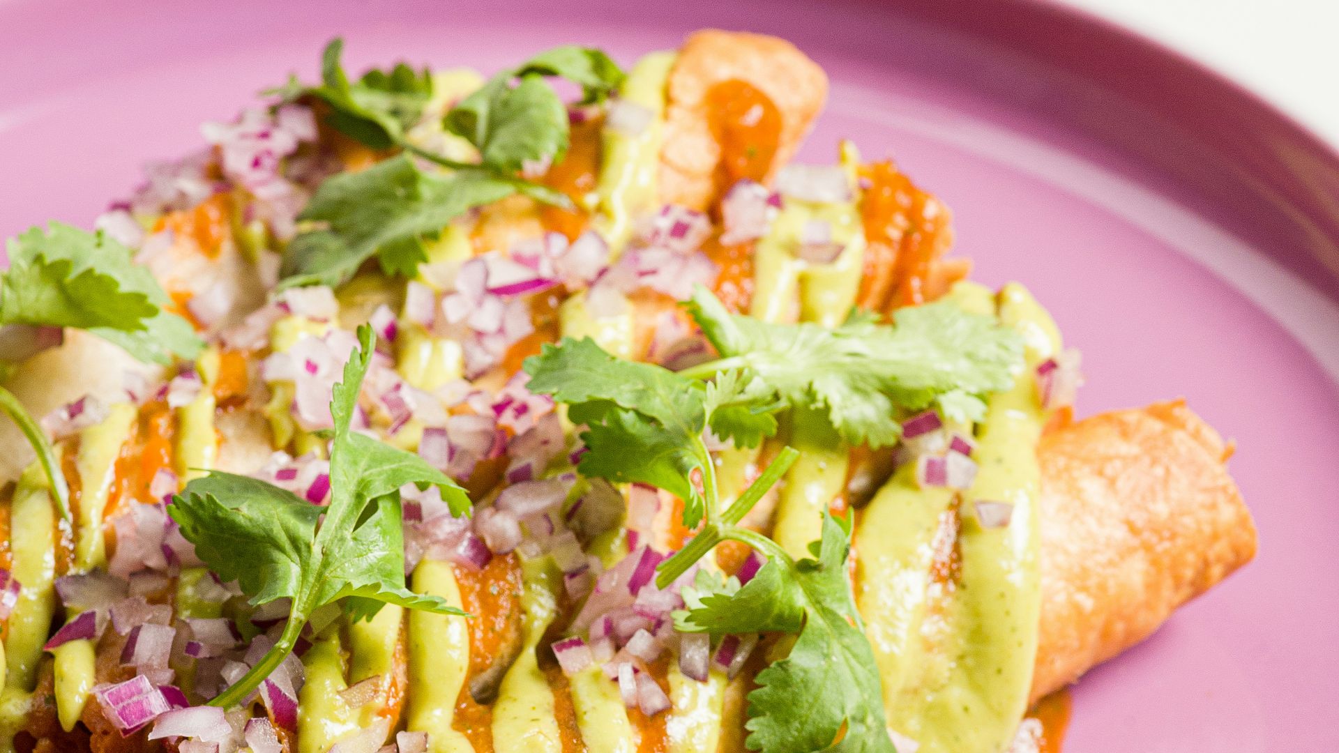 a pink plate topped with food on top of a table