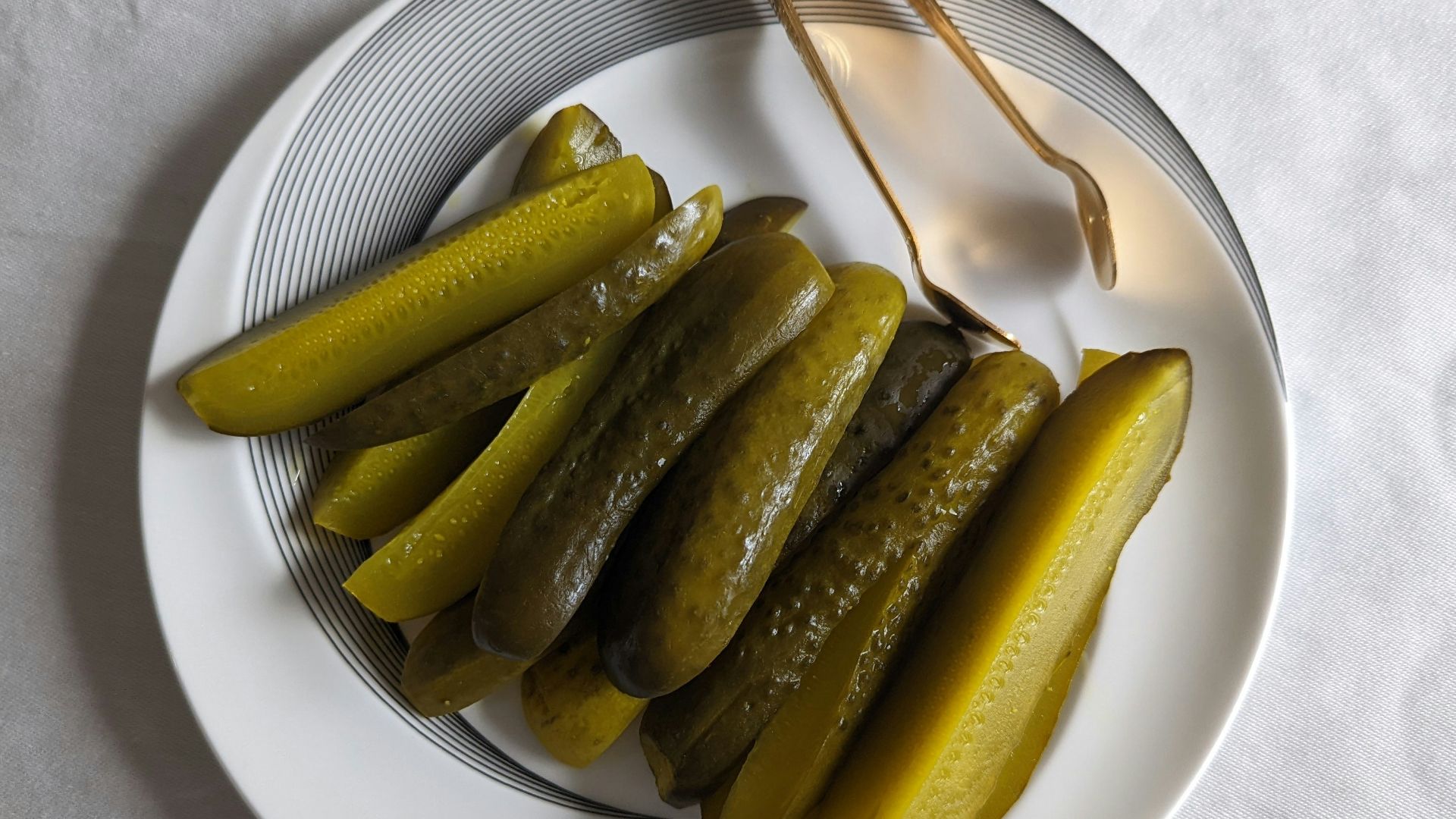 a white plate topped with pickles next to a fork