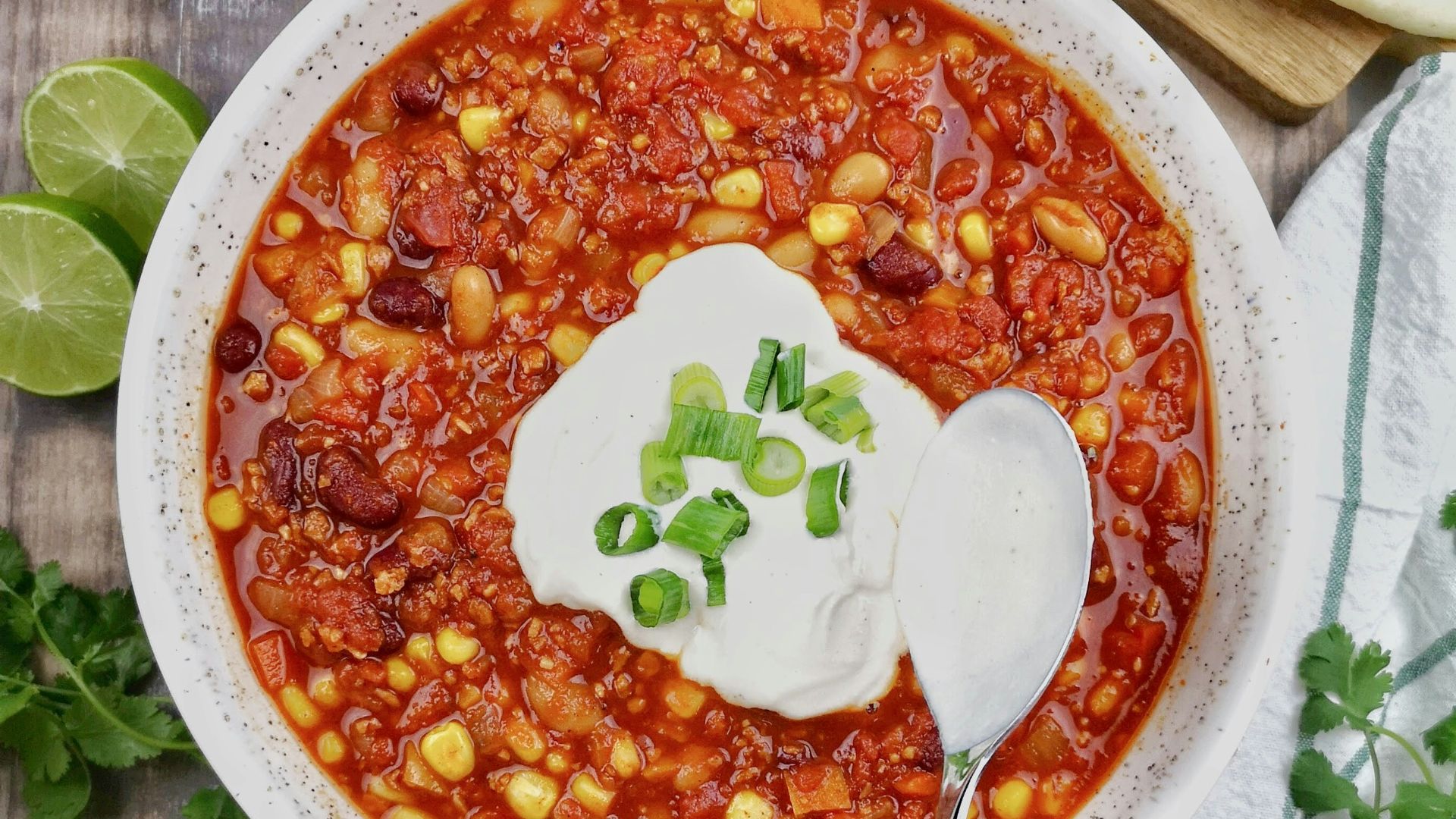 a bowl of chili with sour cream on top