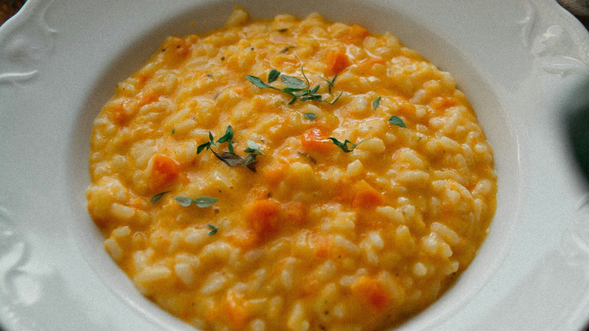a white plate topped with a bowl of macaroni and cheese