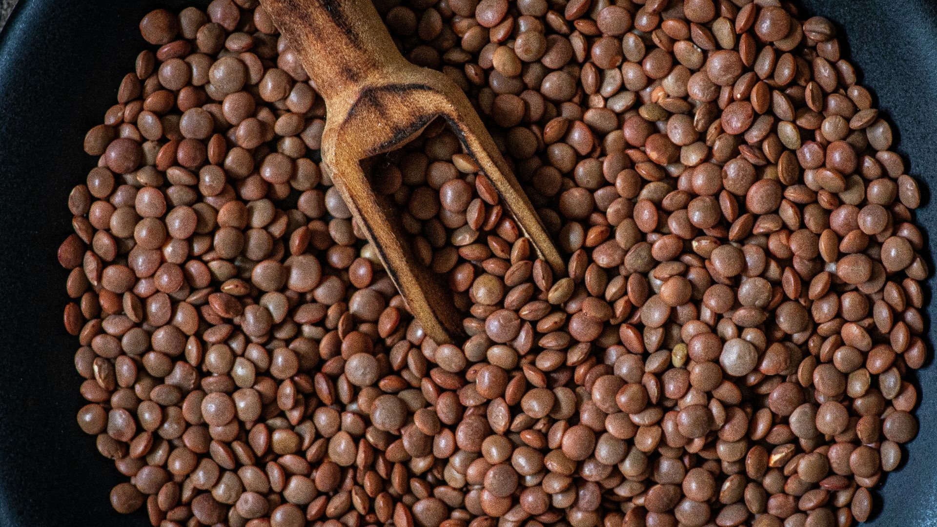 a pan filled with beans and a wooden spoon