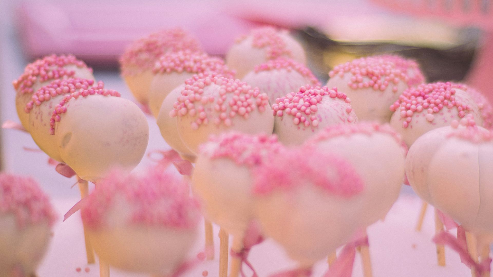 a group of pink and white cupcakes with frosting