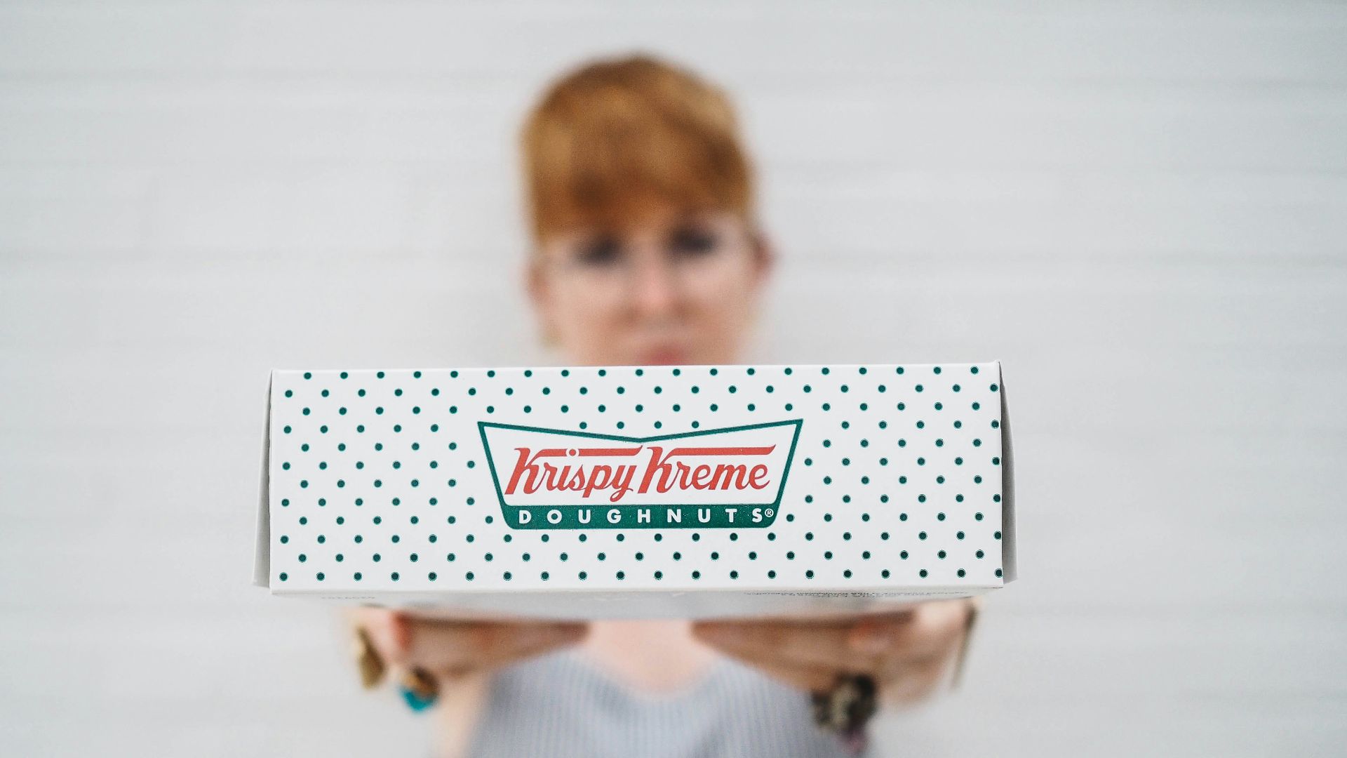 woman showing Krispy Kreme box