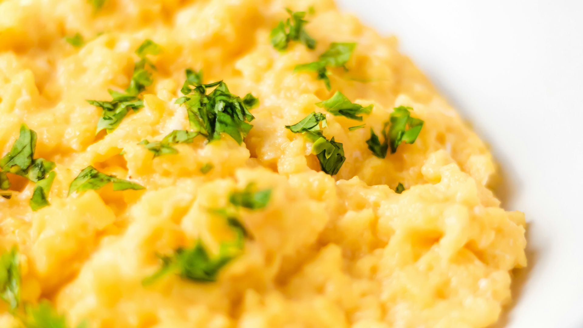 a bowl of mashed potatoes with parsley on top
