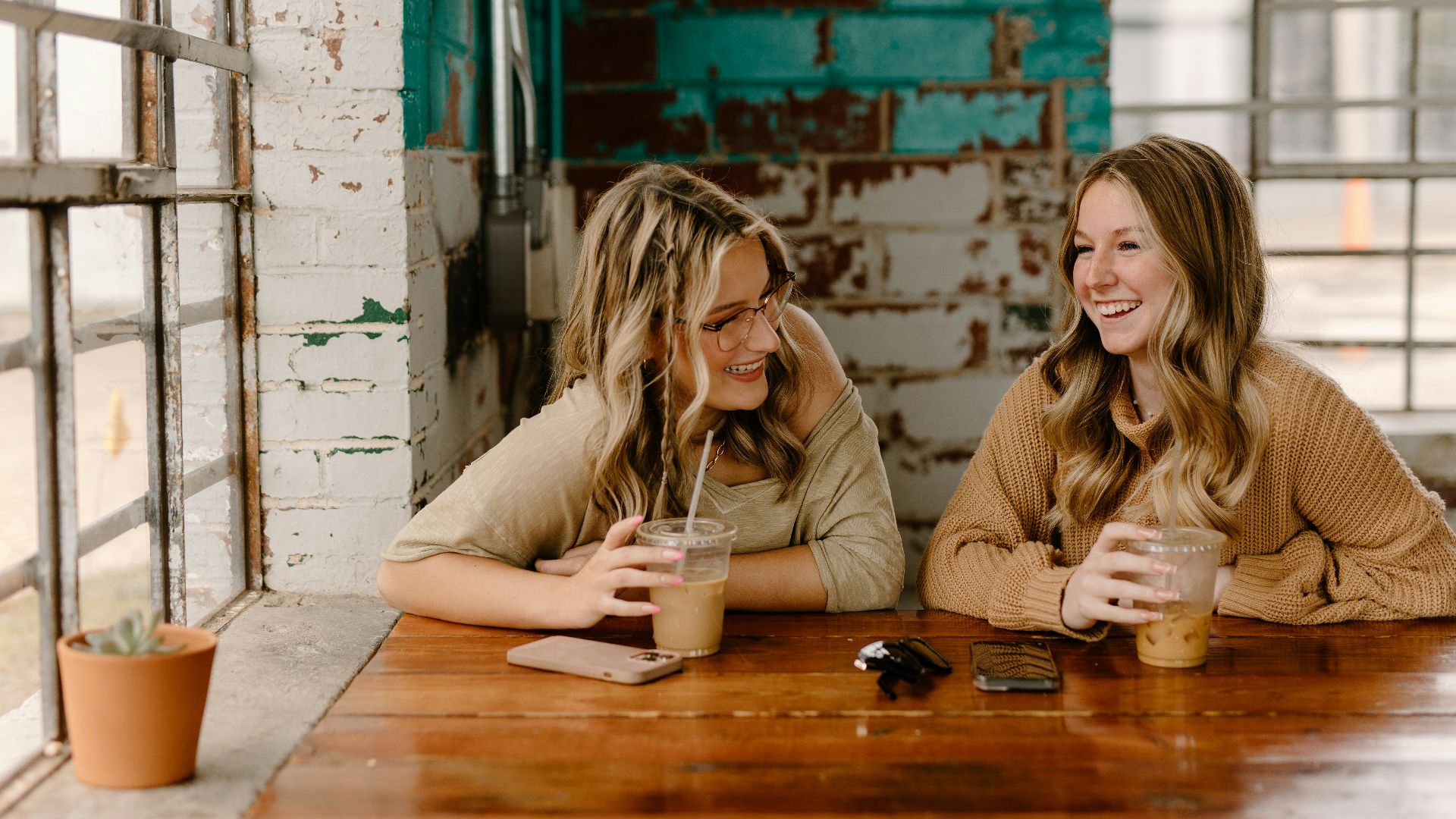 two women sitting at a table with drinks