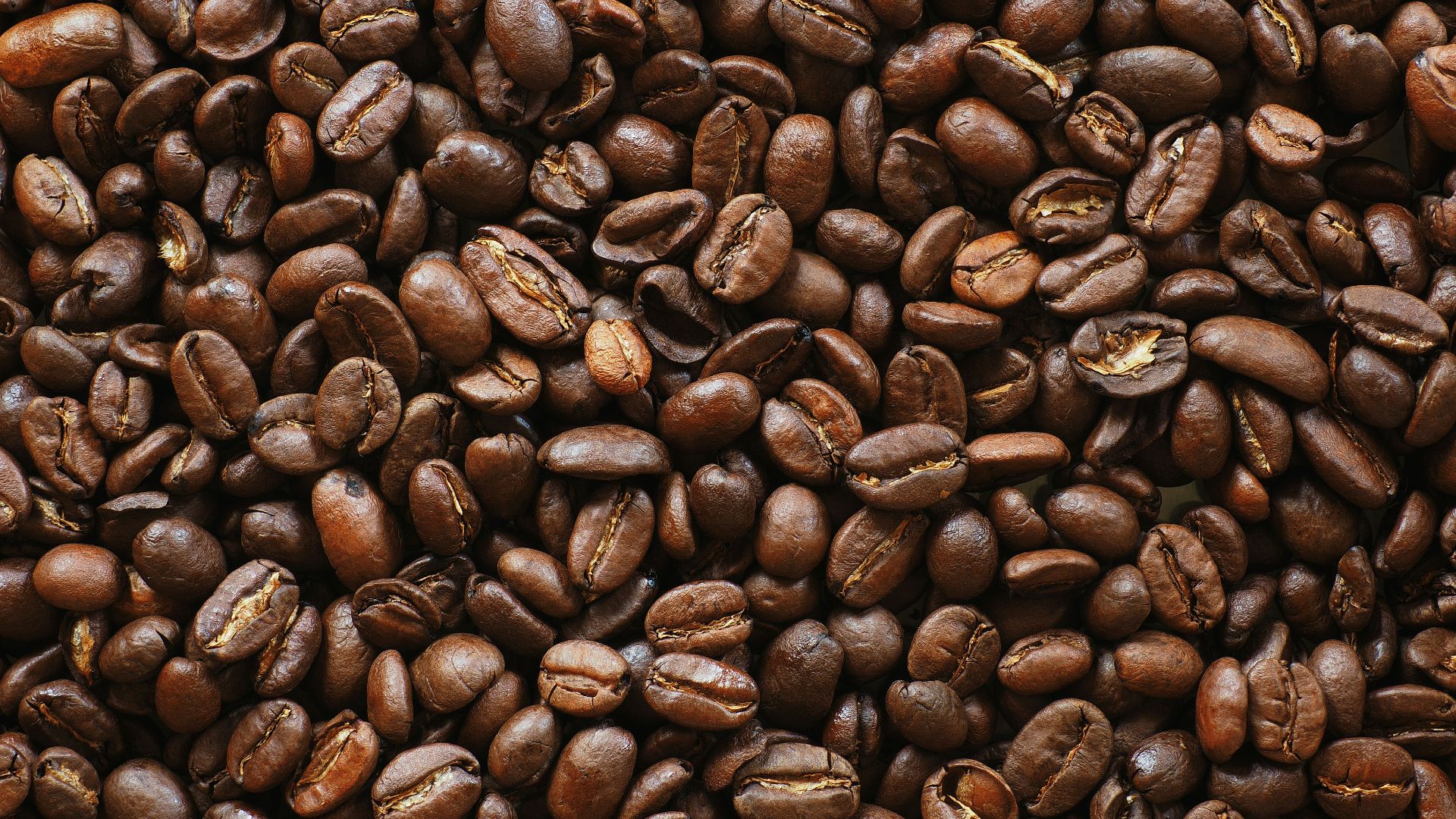 brown coffee beans on black surface