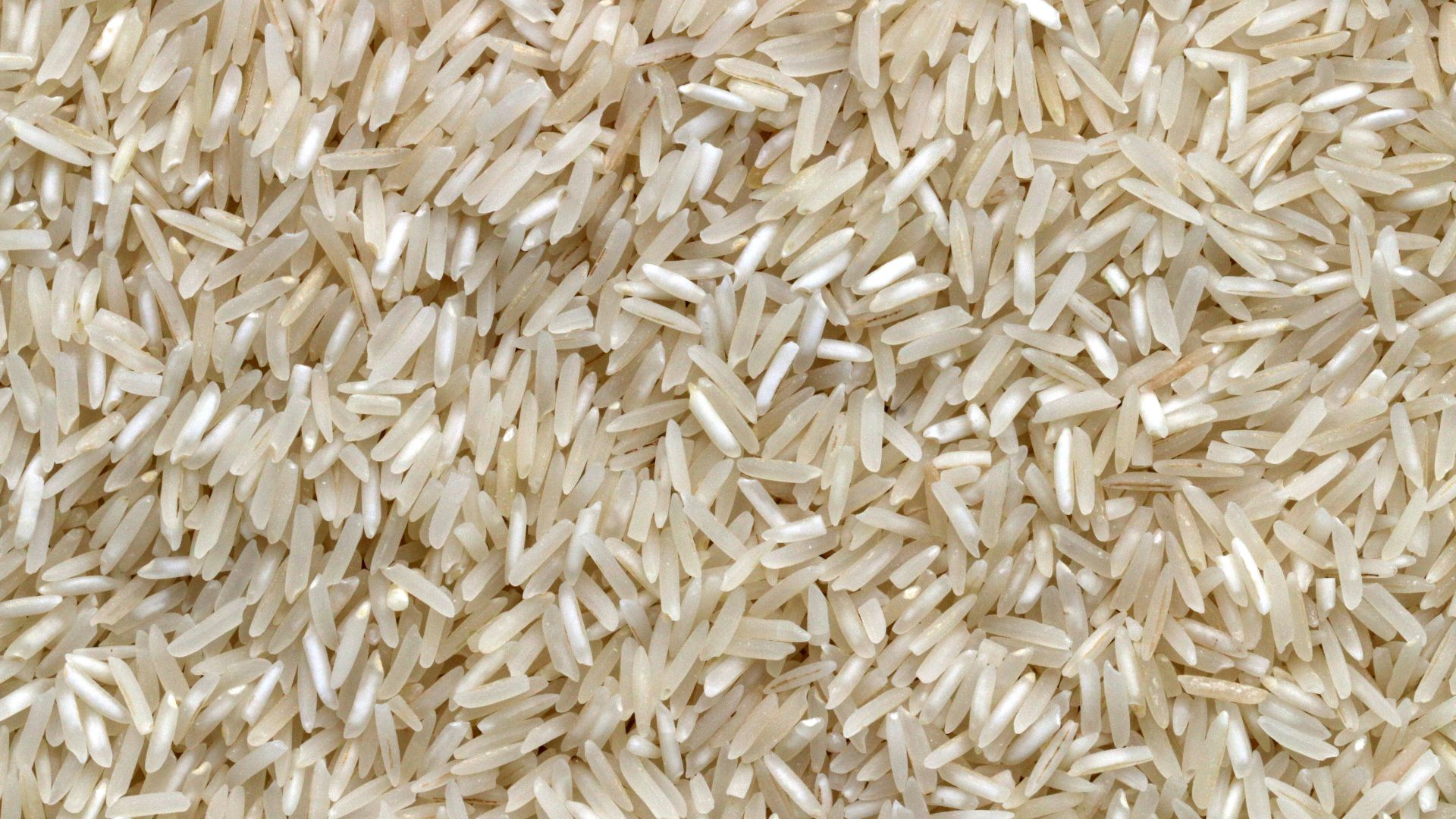 white rice grains on brown wooden table