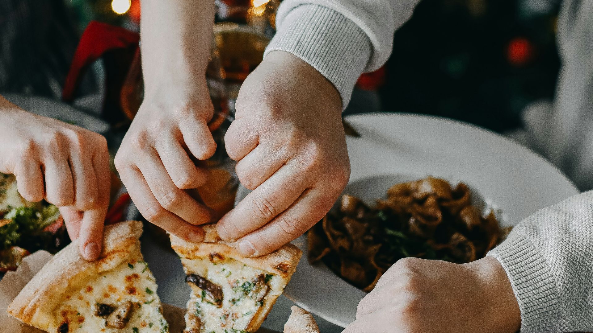 a group of people eating pizza